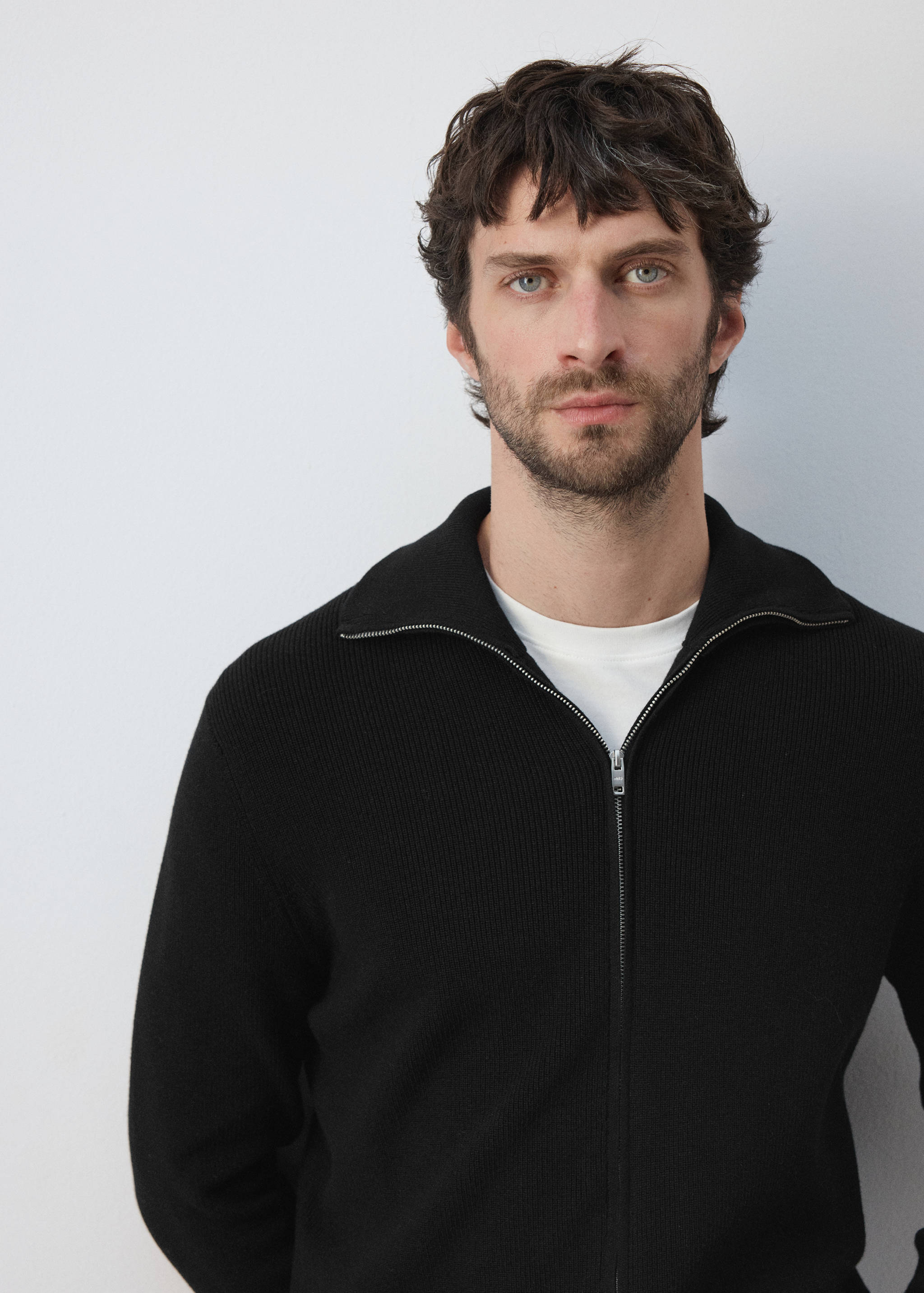 Black ribbed-knit zip-up cardigan with a collar.