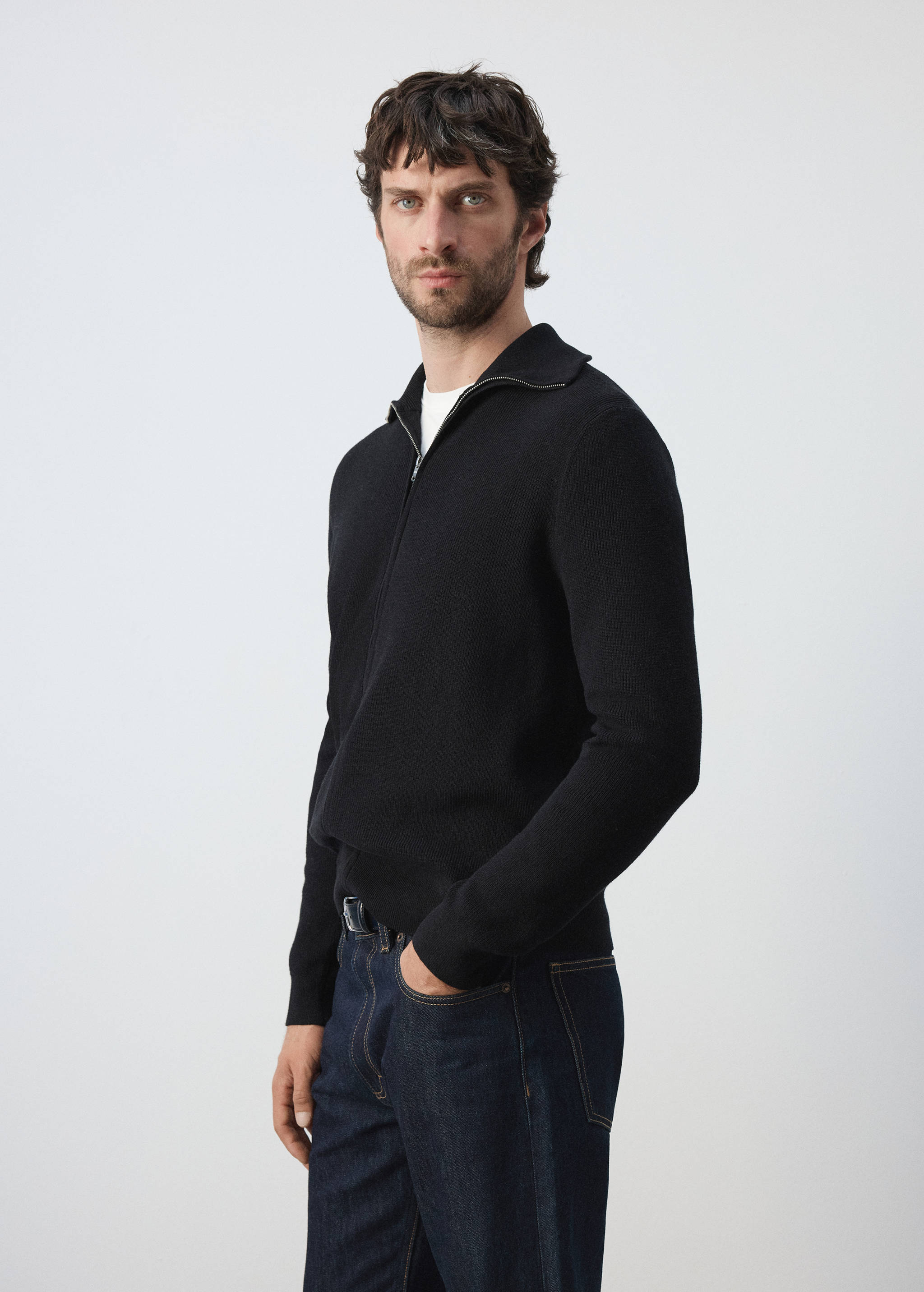 Black zip-up cardigan with collar worn over a white t-shirt.