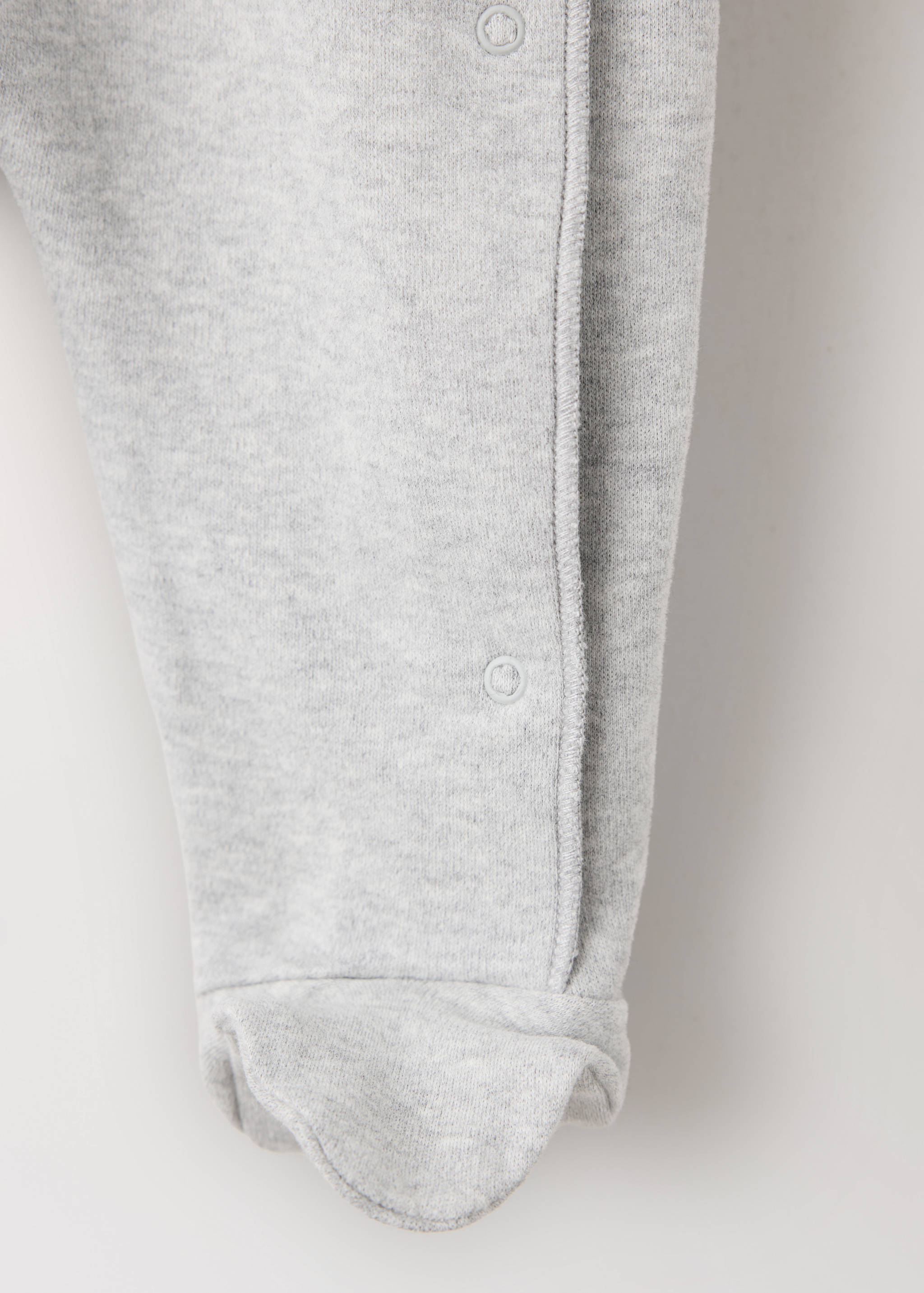 Grey marl baby sleepsuit detail showing snap button closure and foot