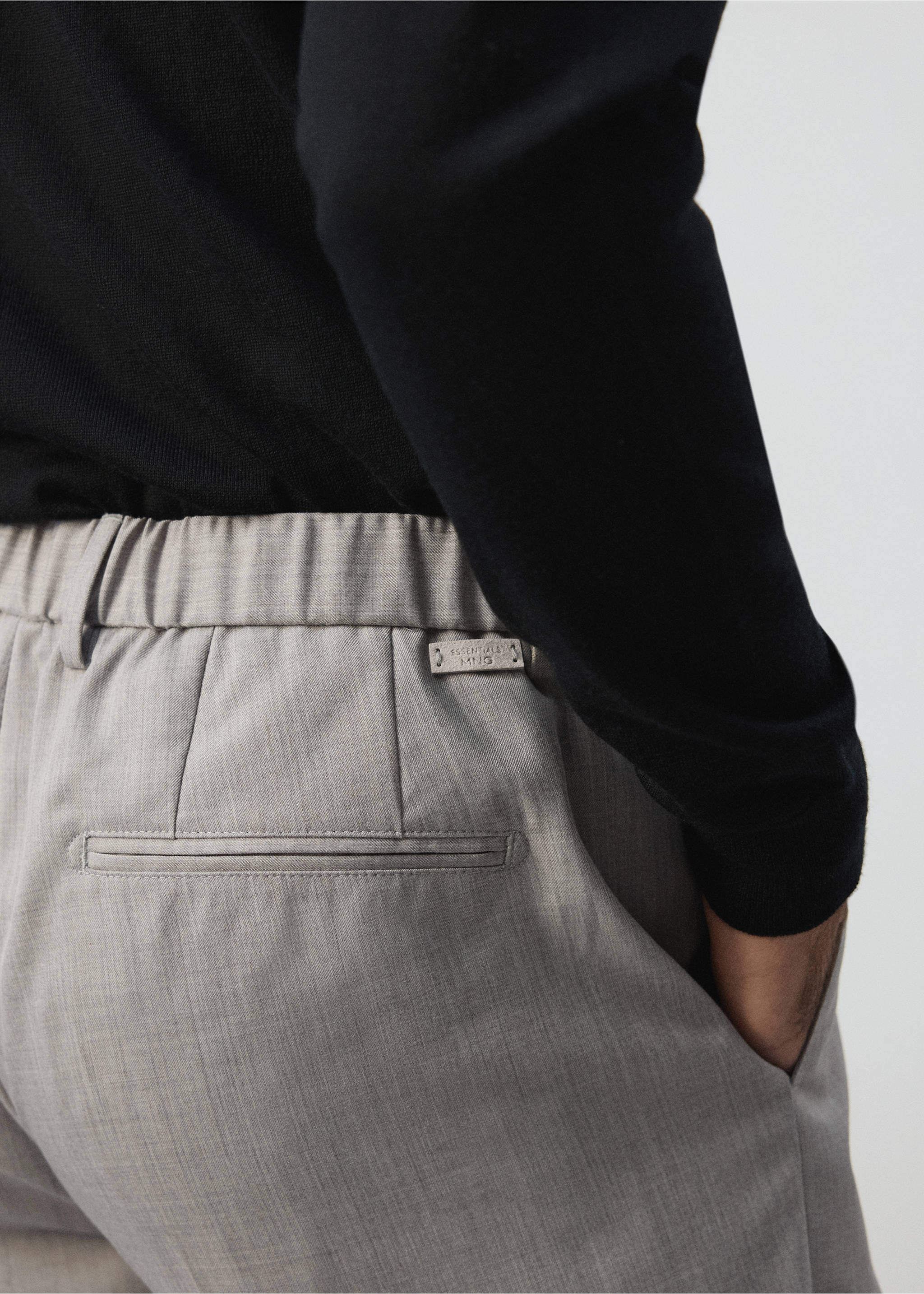 Close-up of light grey trousers with an elasticated waistband and welt pocket., Light/Pastel Grey. Ref: 37065975-02.