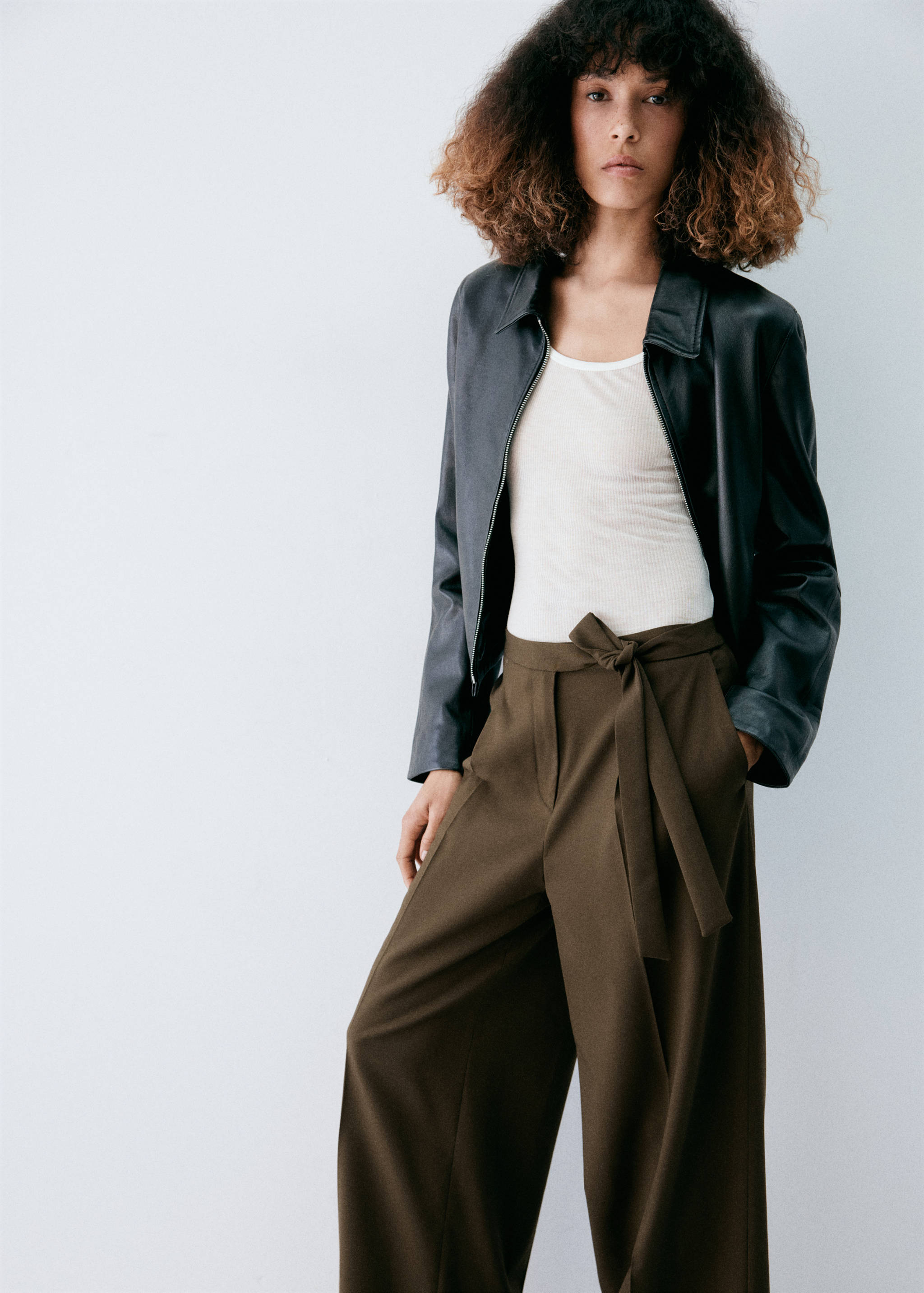 Dark olive-green high-waisted wide-leg trousers with a self-tie belt.