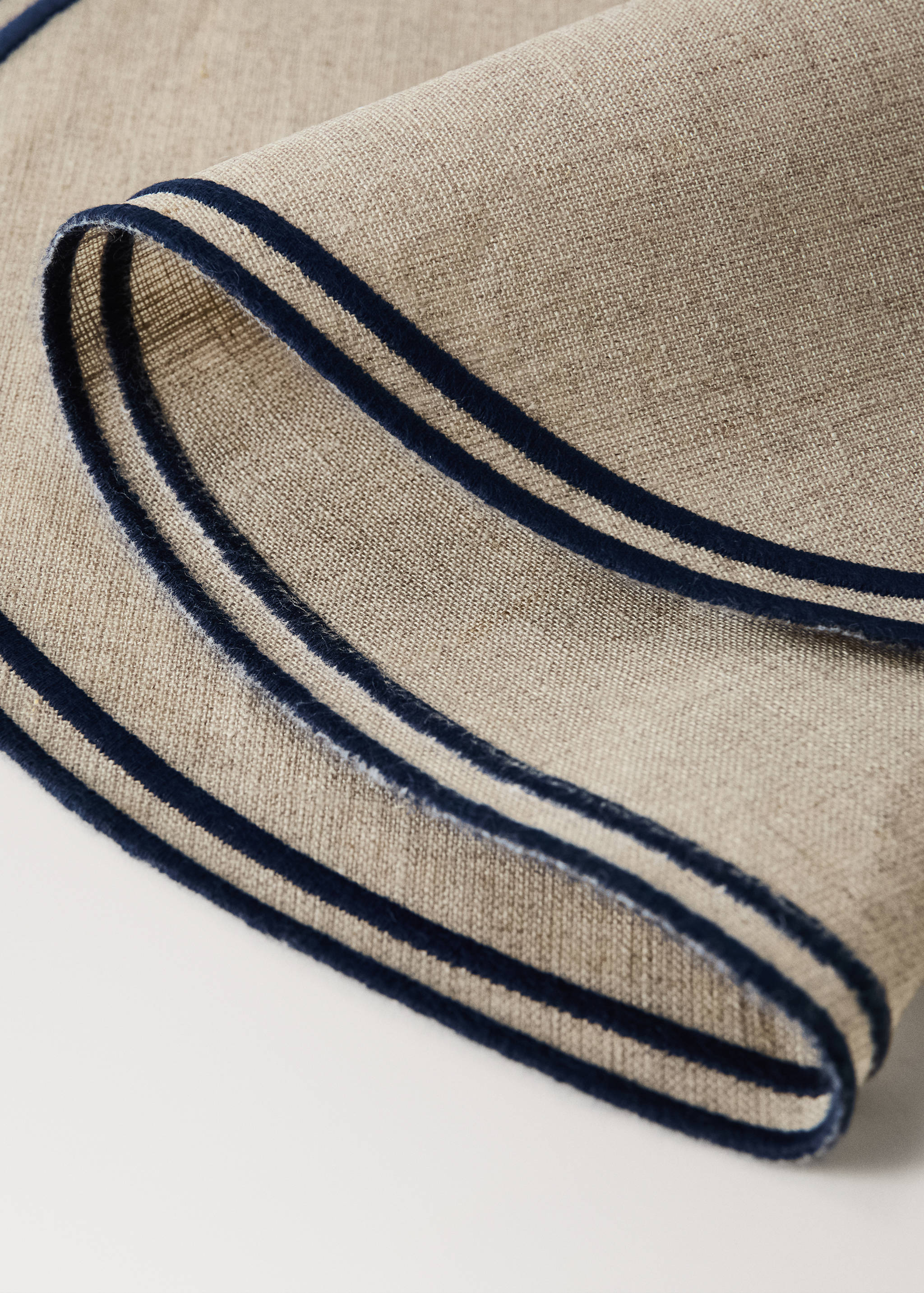 Beige placemat detail with a contrasting dark blue double border.