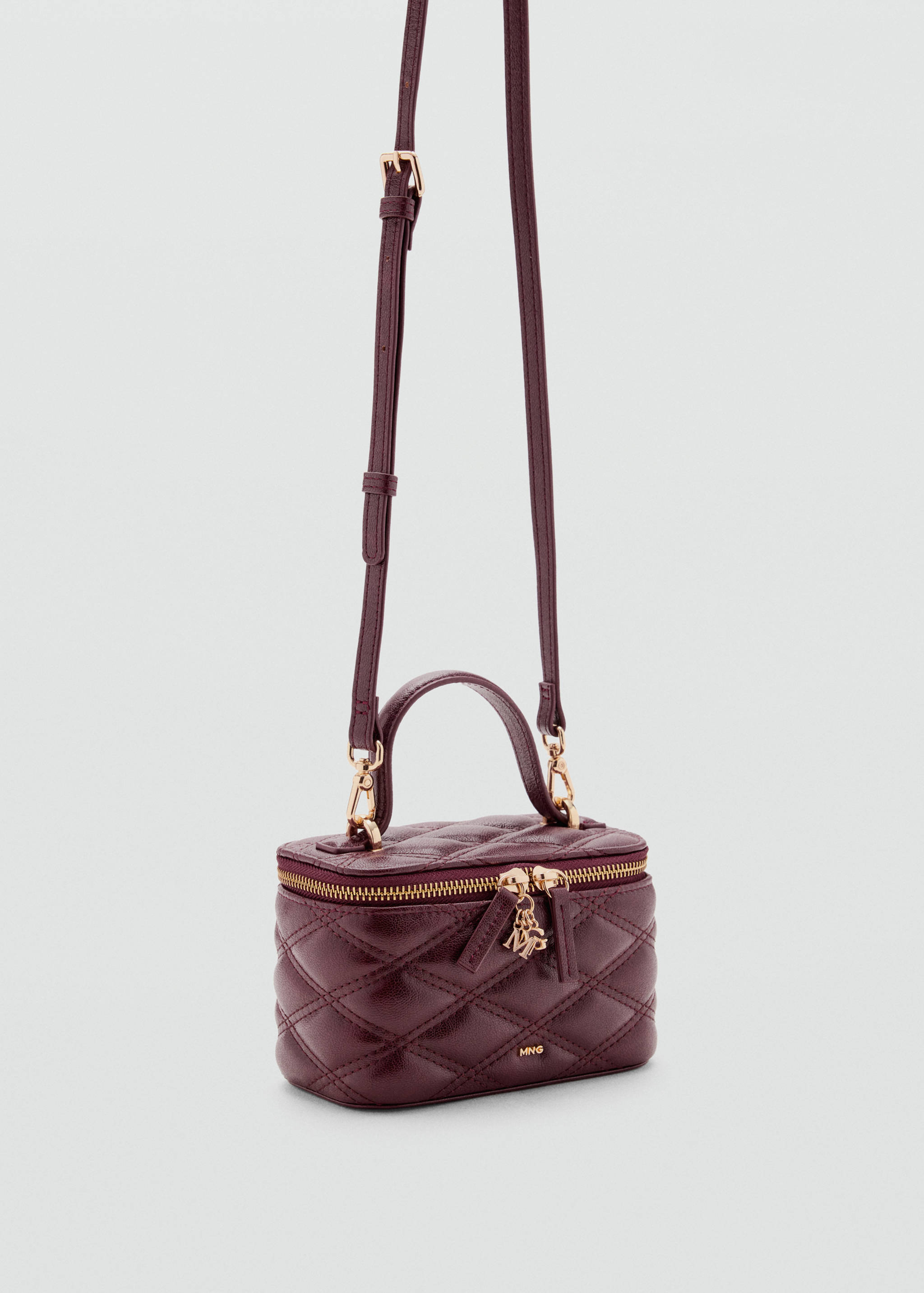 Burgundy quilted vanity bag with gold hardware and a shoulder strap.