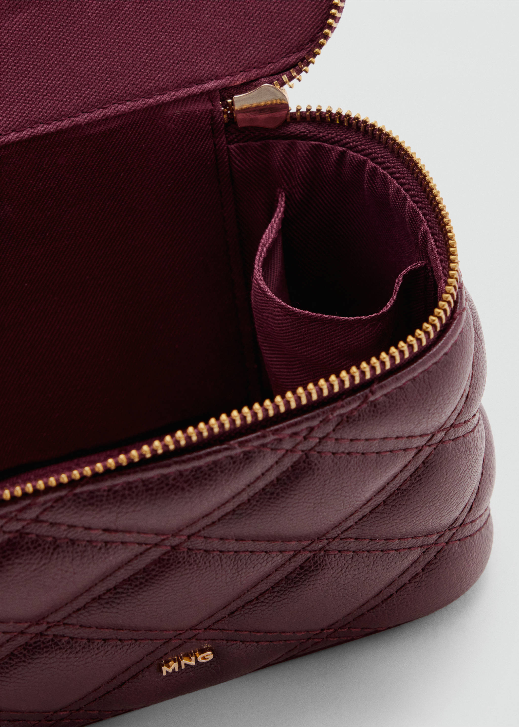 Close-up of a quilted burgundy vanity case interior with gold zip., Cherry. Ref: 37066365-00.
