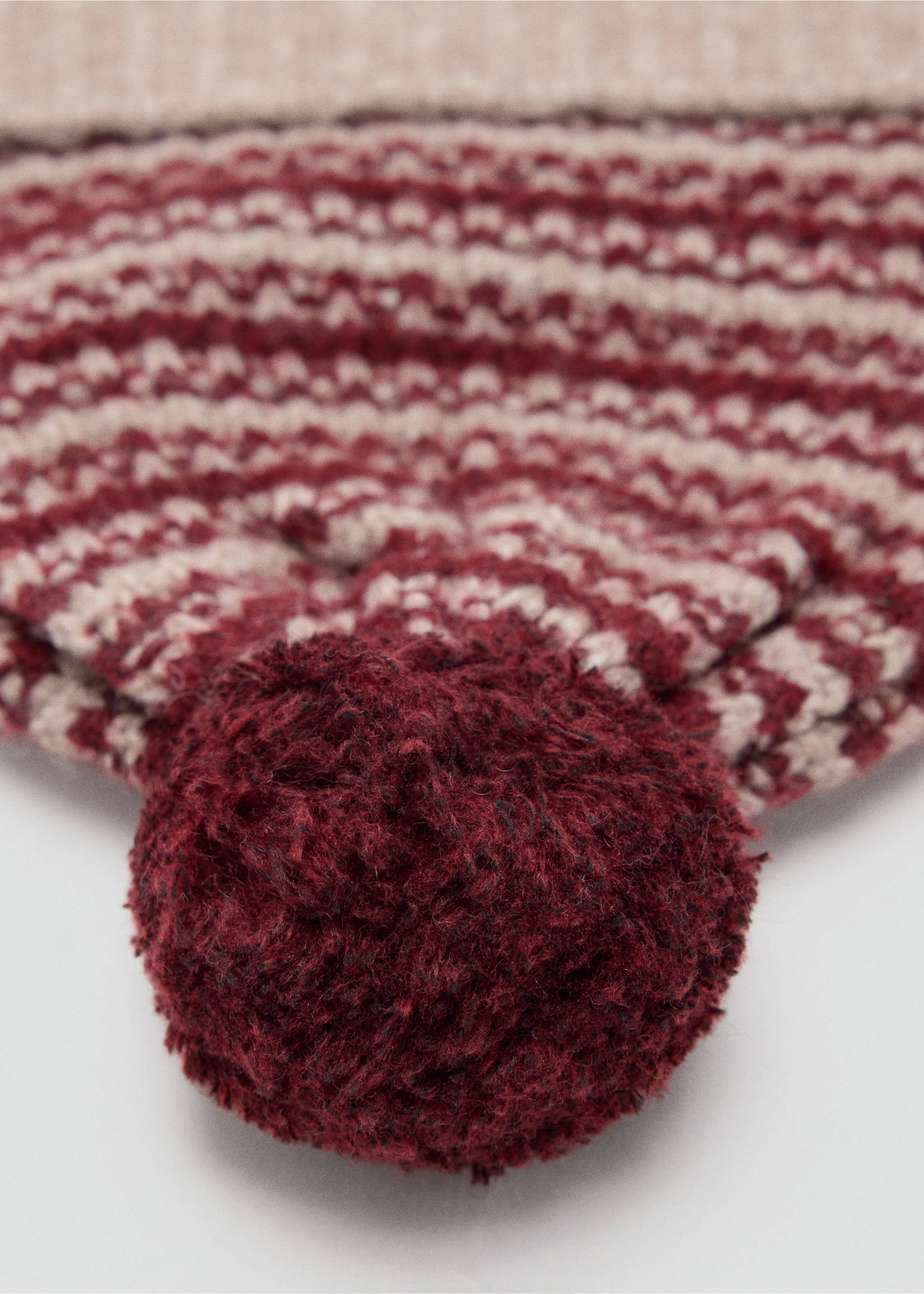 Close-up of a burgundy and beige patterned knit beanie with a pom-pom., Maroon. Ref: 37066367-00.