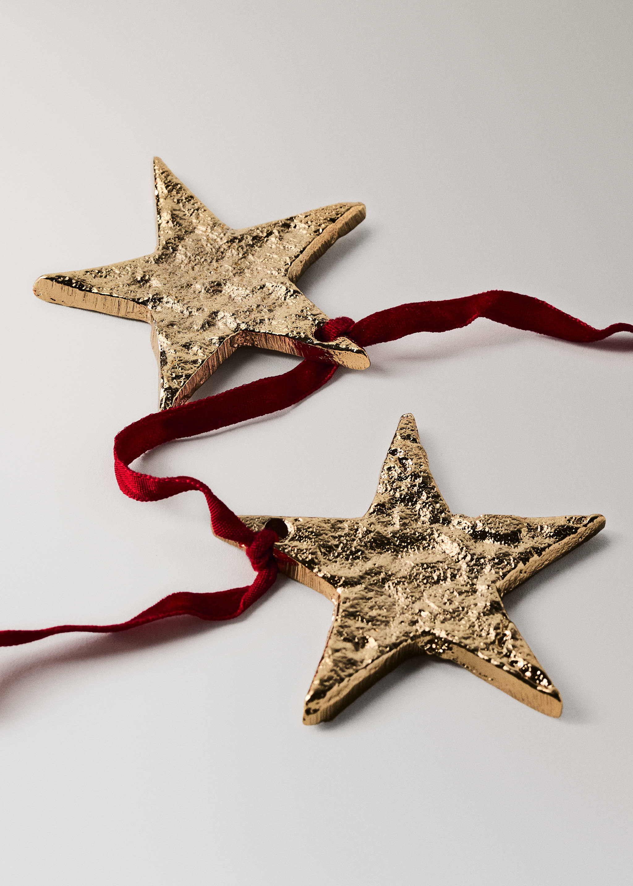 Textured gold star garland with a dark red velvet ribbon.