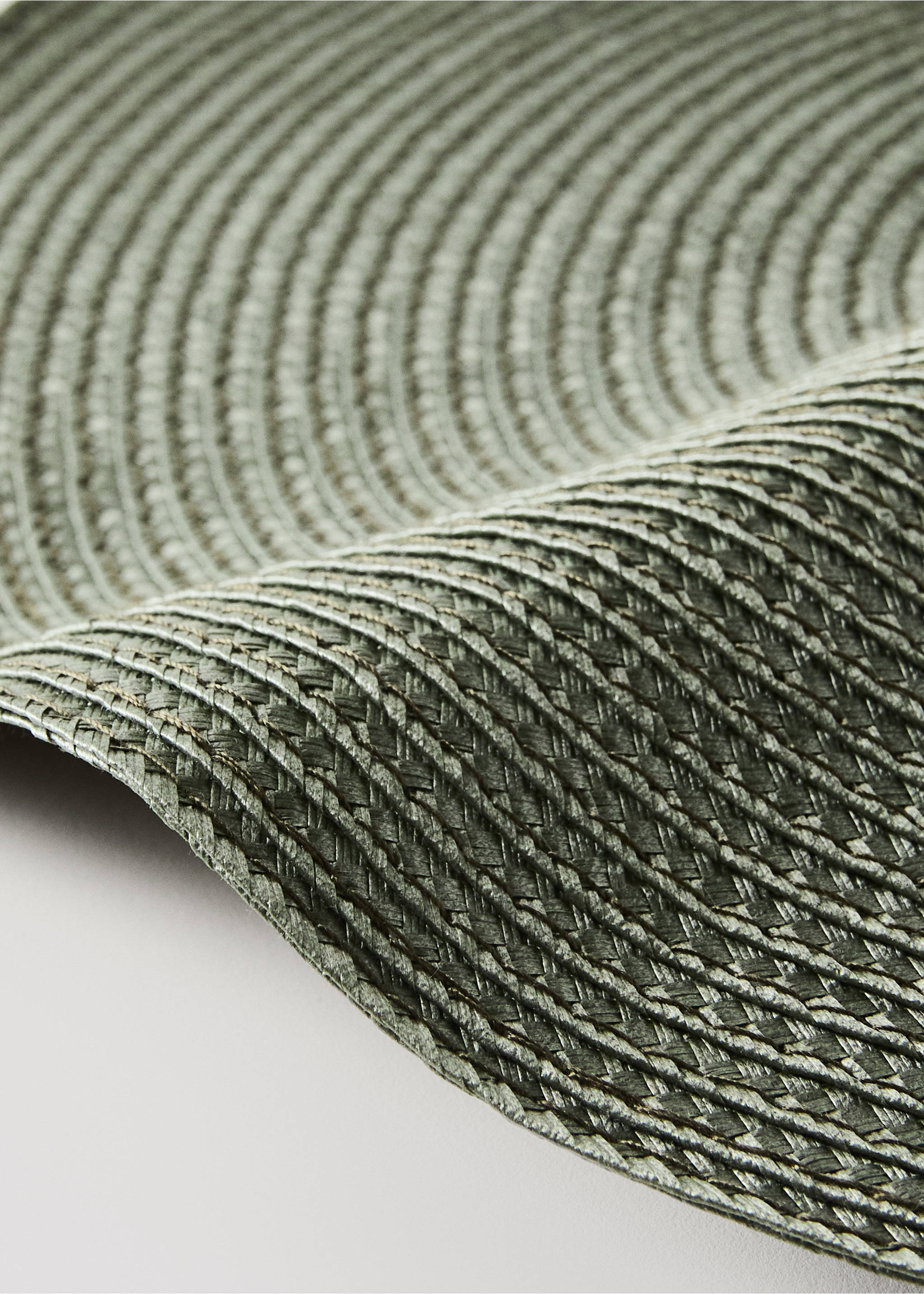 Close-up of a green woven placemat with concentric braided texture., Green. Ref: 37066732-00.