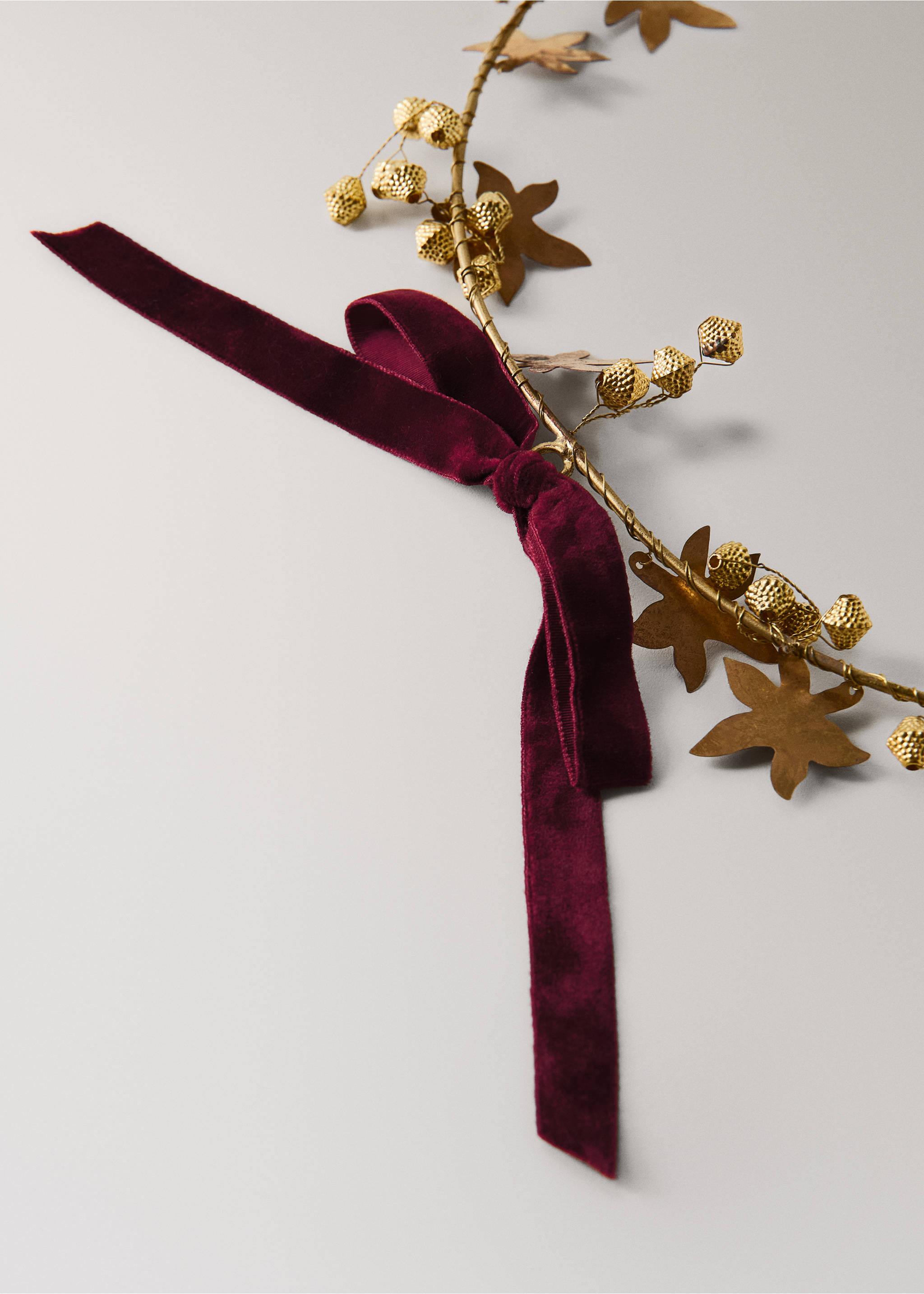 Decorative gold wire garland with metallic leaves, acorns, and a burgundy velvet bow., Gold. Ref: 37066735-00.