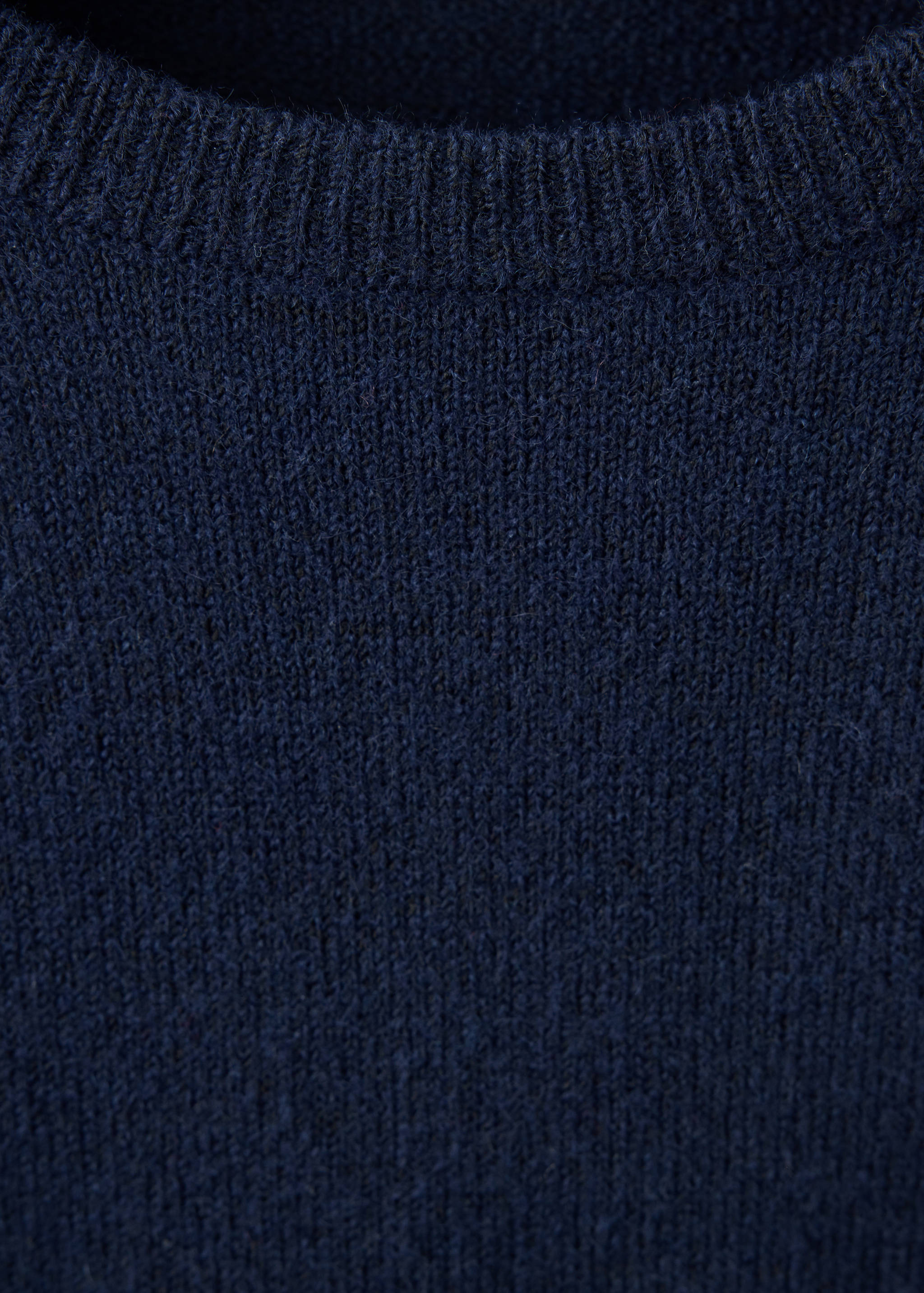 Close-up of a dark navy blue jersey with a ribbed crew neck.