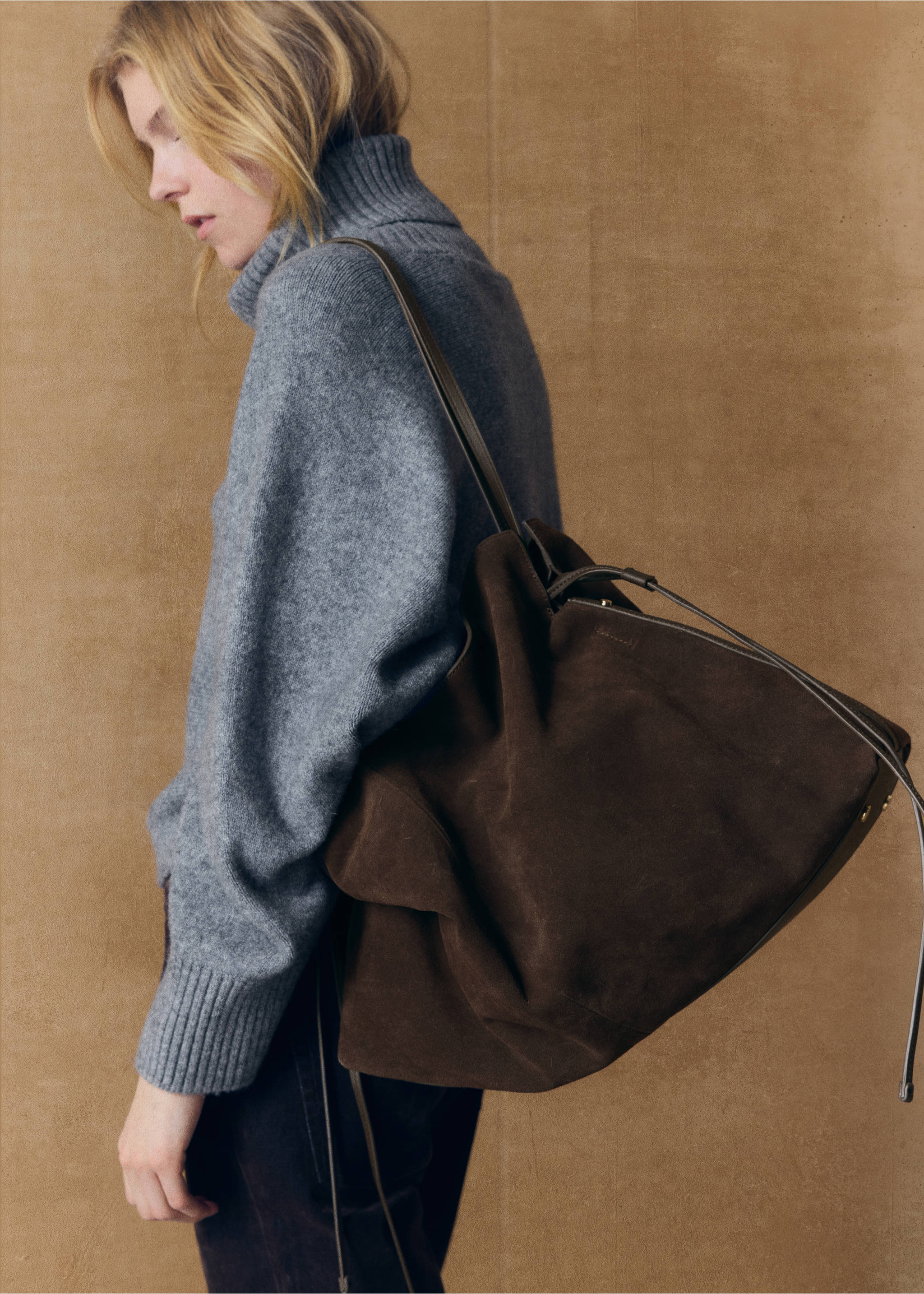 Dark brown suede bucket bag with thin shoulder straps and a slouchy silhouette worn on a shoulder., Chocolate. Ref: 37067132-01.