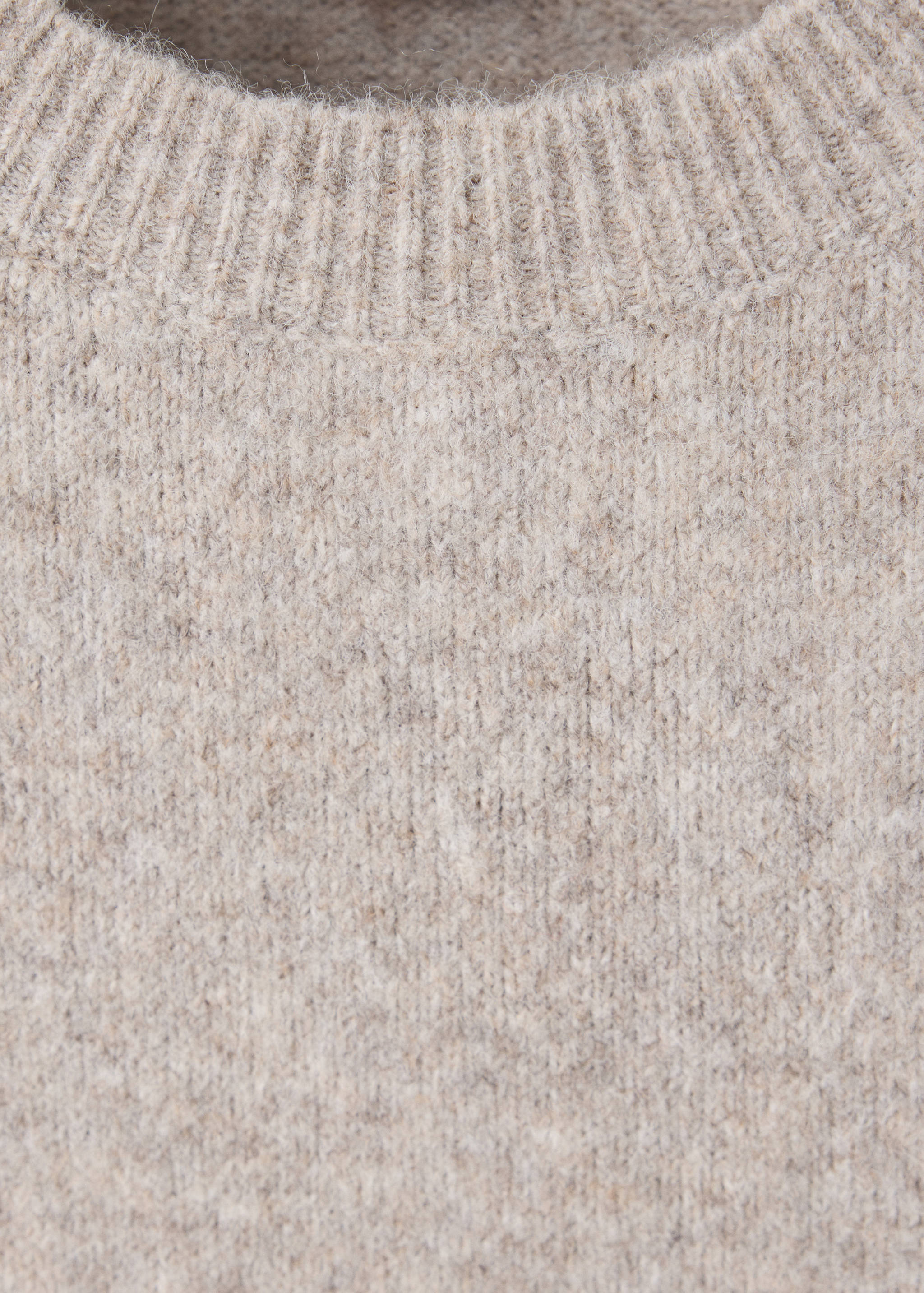 Close-up of a ribbed round neckline on a beige marled knit dress.