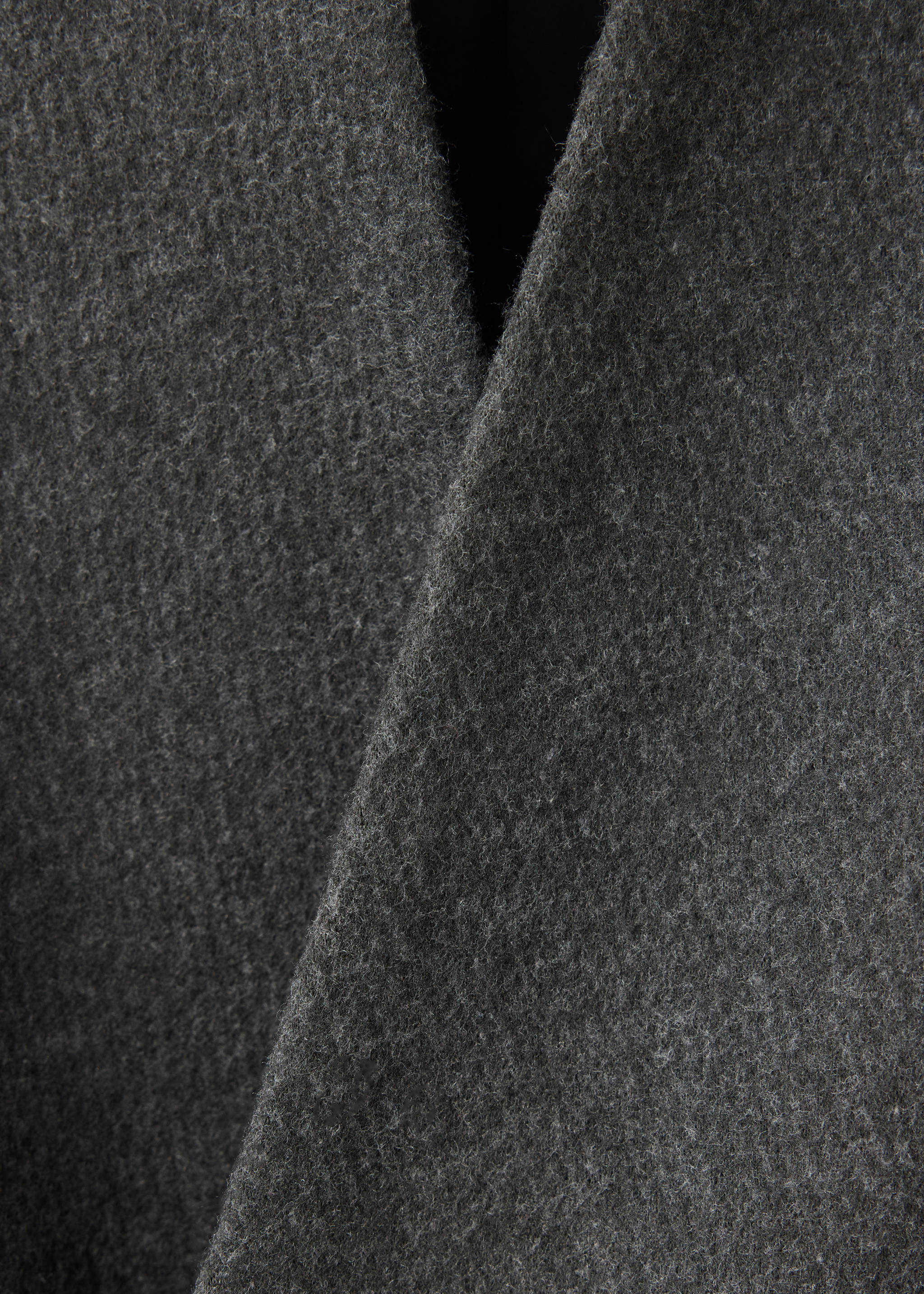 Close-up of the dark grey textured fabric on a coat.