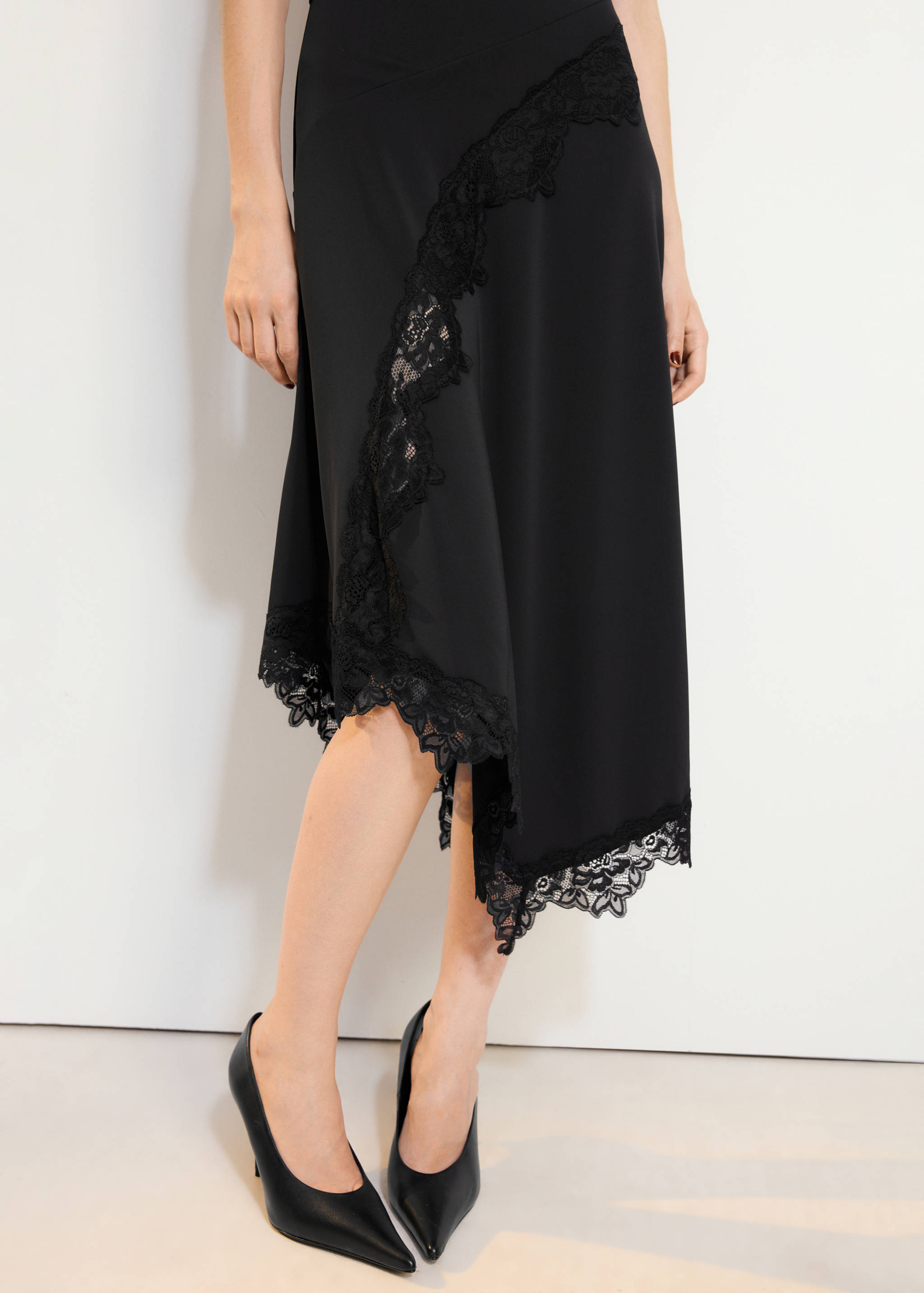 Vestido midi negro con ribete de encaje asimétrico y bajo irregular.