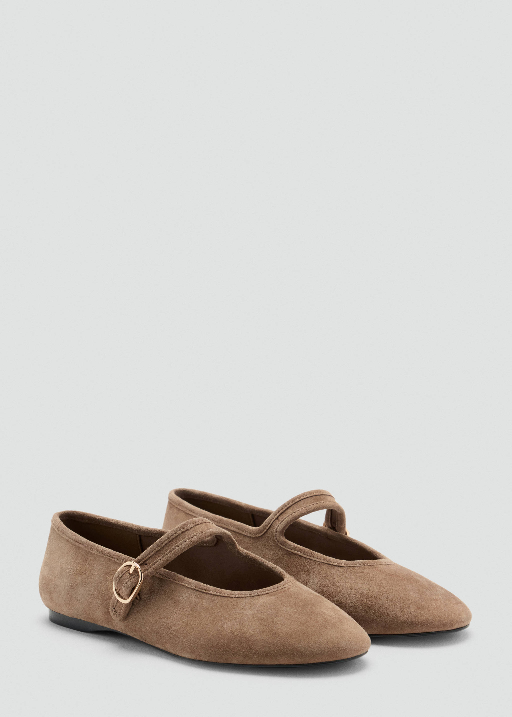 Brown flat shoes with a rounded toe and a buckled instep strap.