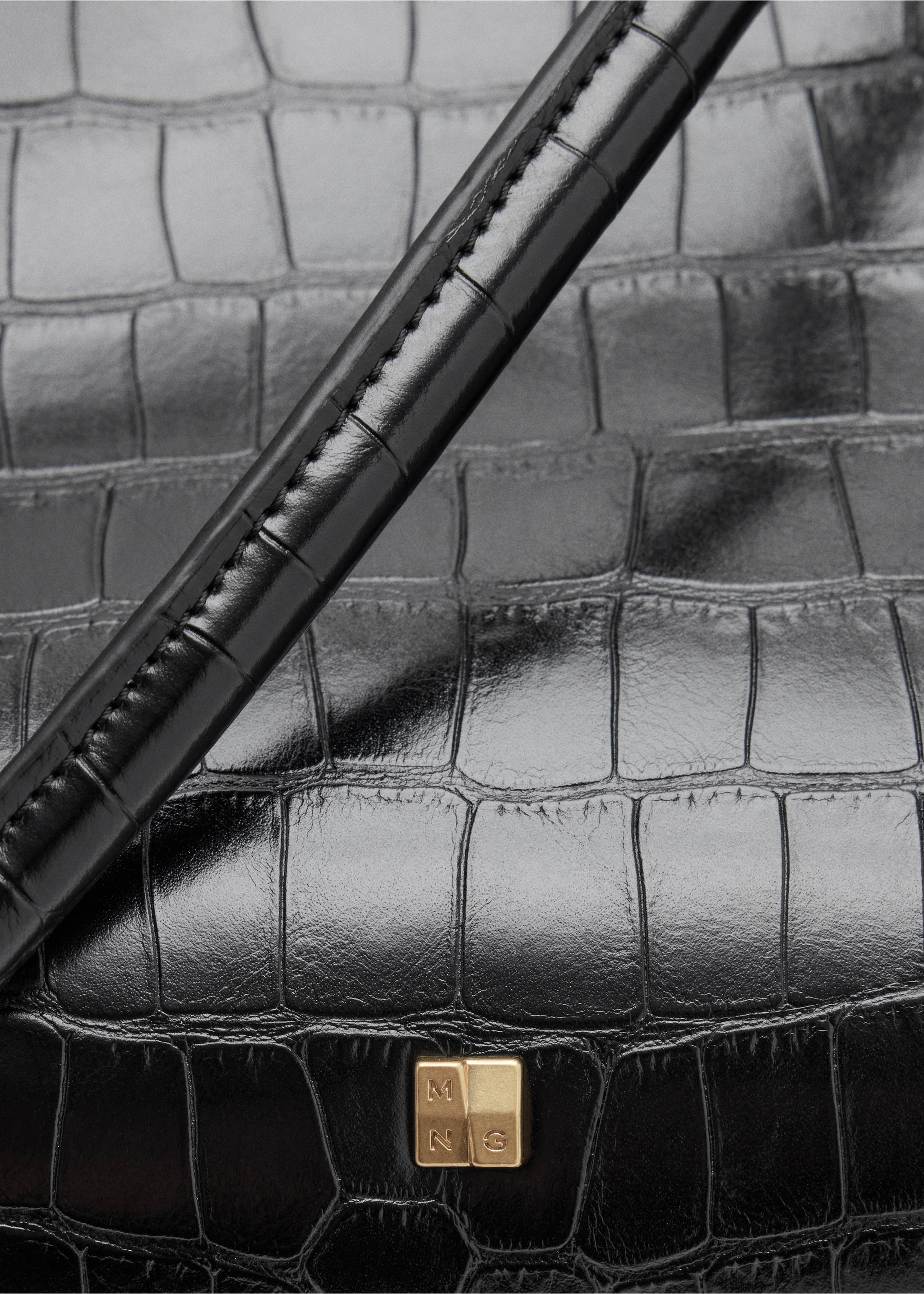 Close-up of a black crocodile-embossed shoulder bag with a gold clasp., Black. Ref: 37067791-00.