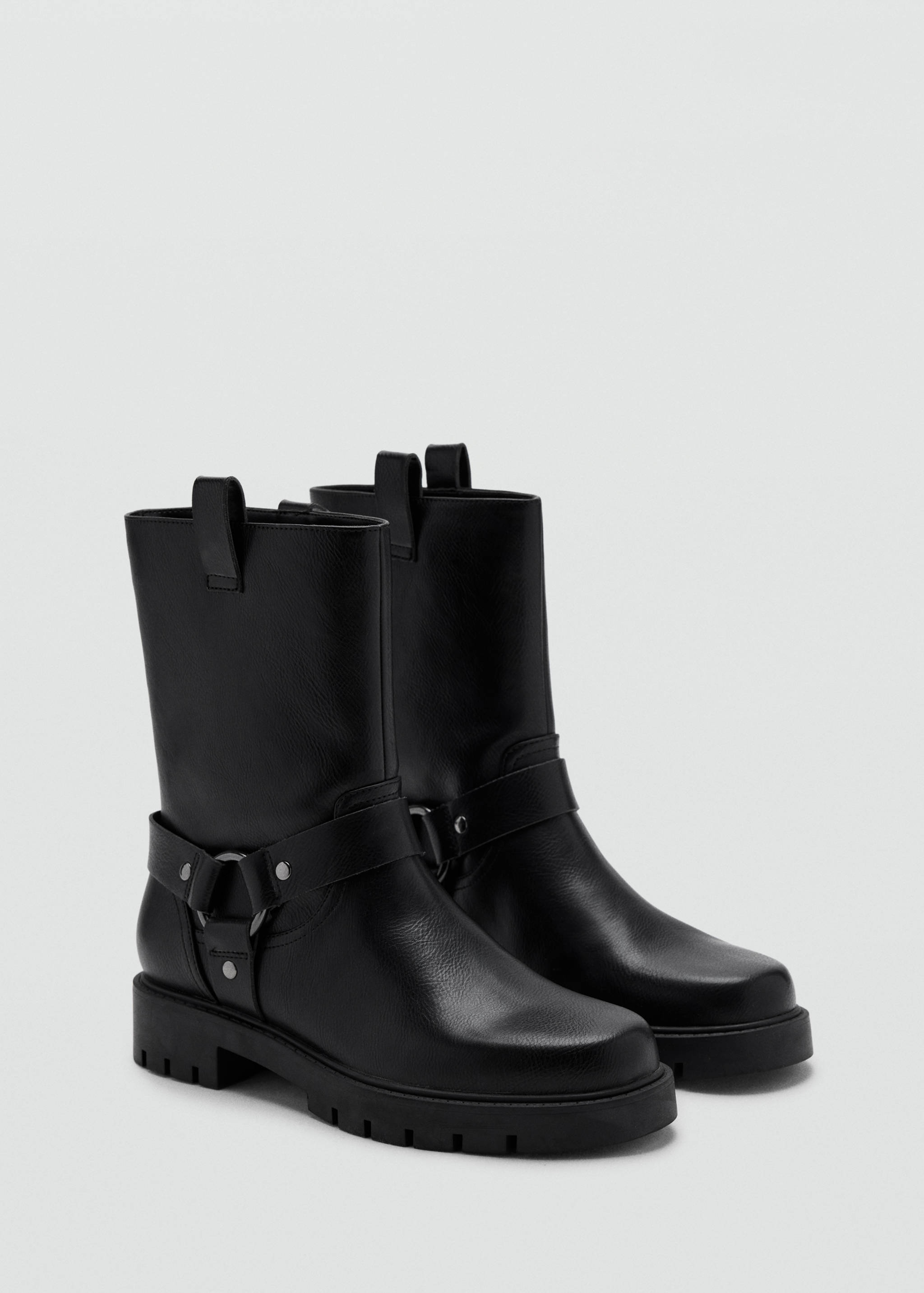 Black leather boots with a lug sole and a harness strap.
