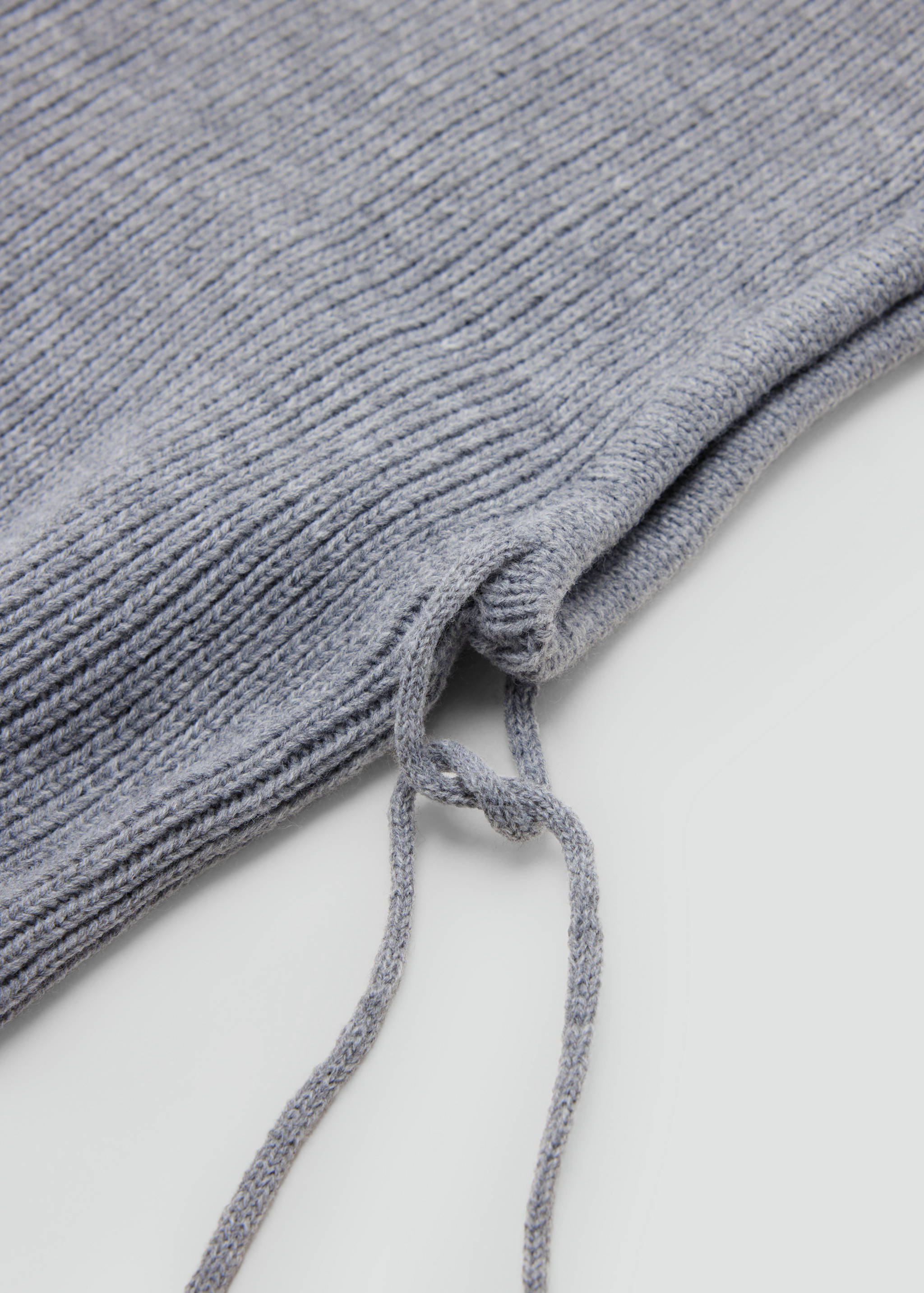 Close-up of a grey ribbed hat detail with a drawstring.