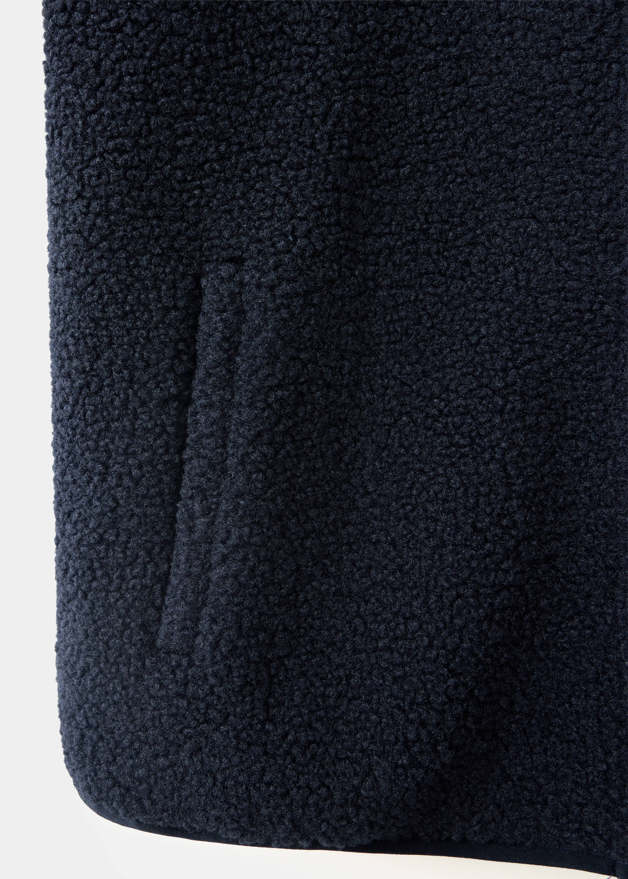 Navy blue jacket fabric detail showing textured fleece and pocket.