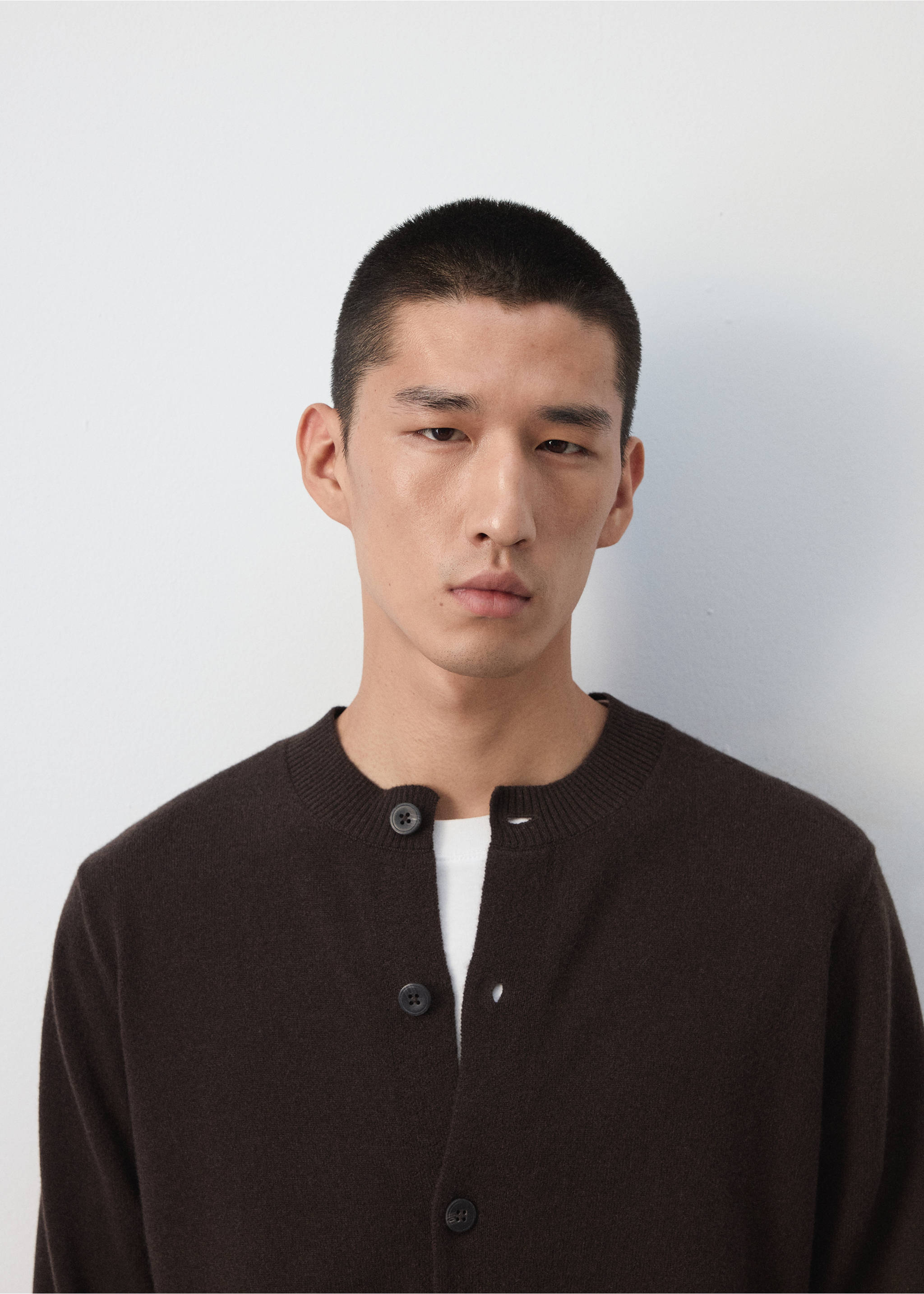Close-up of a dark brown knitted cardigan with a round neckline worn by a model., Chocolate. Ref: 37067886-00.
