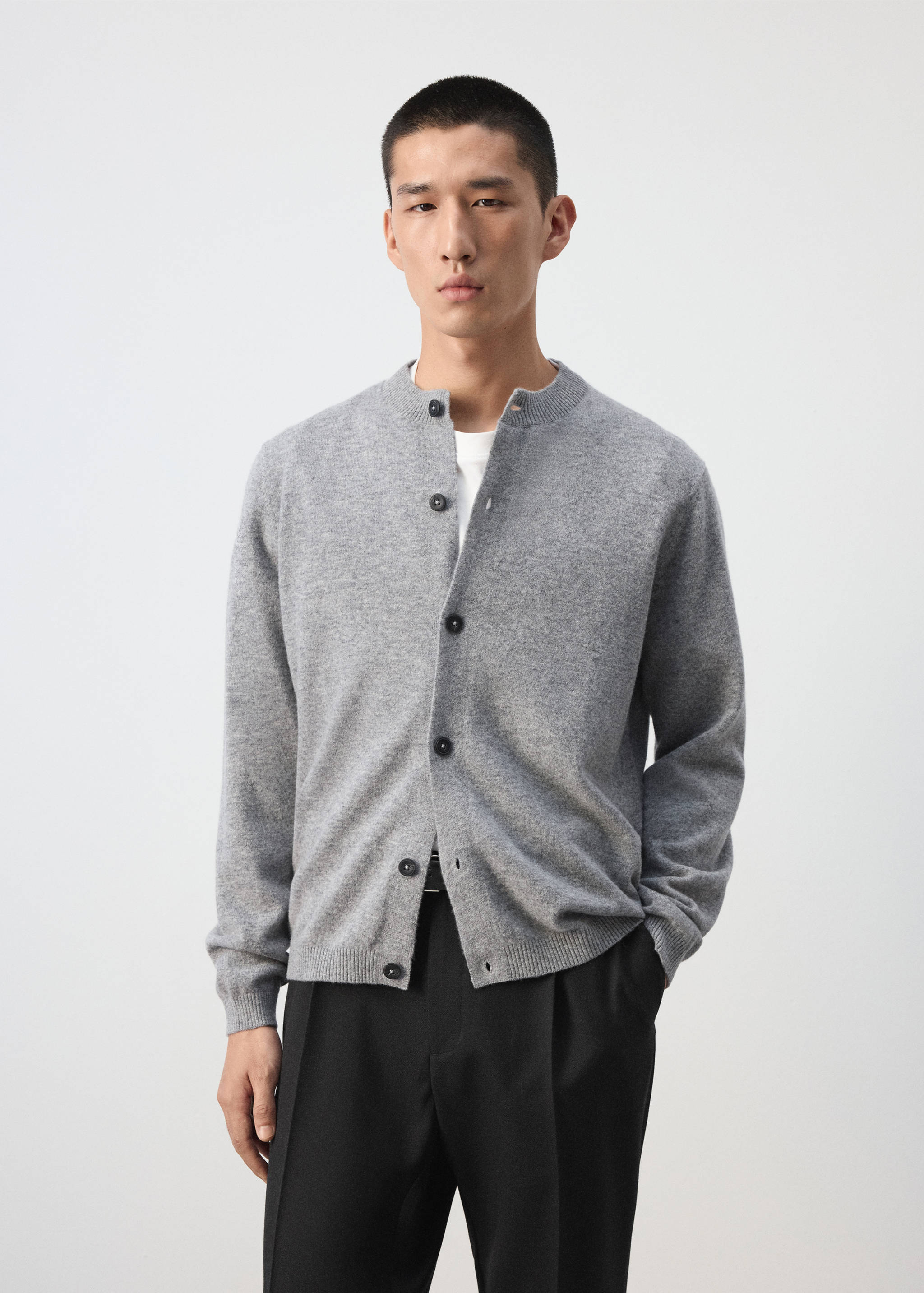 Grey knit cardigan with a round collar and dark front buttons.