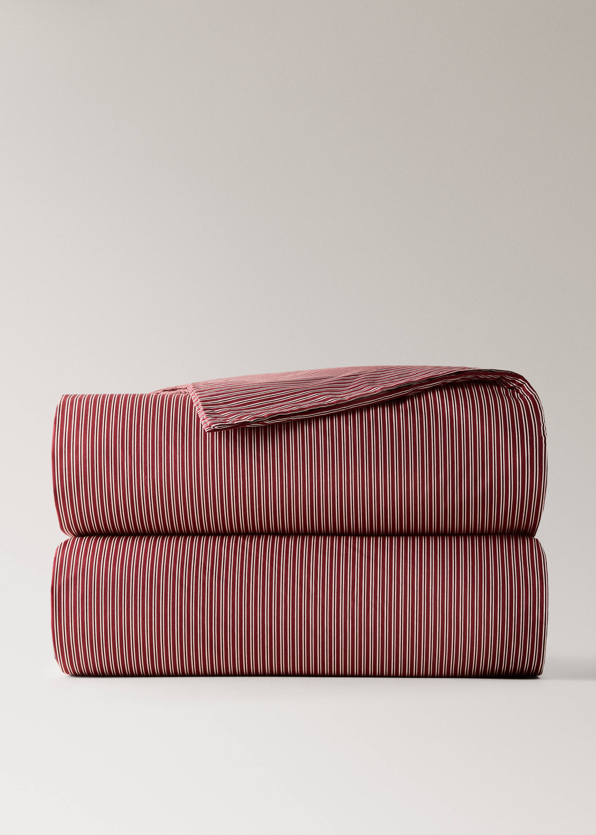 Red and white striped duvet cover folded in a neat stack.