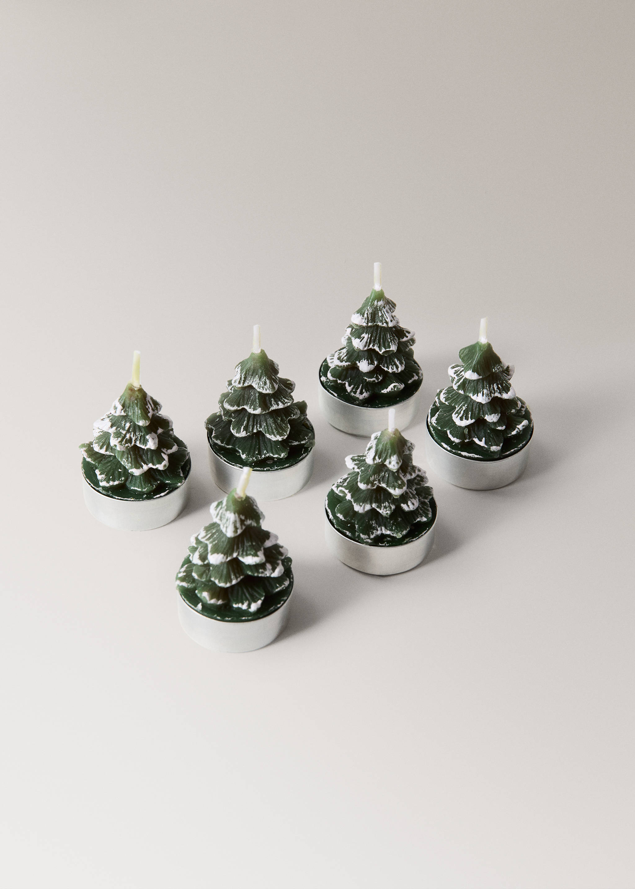 Set of six green Christmas tree-shaped tea light candles with snow-effect white tips.