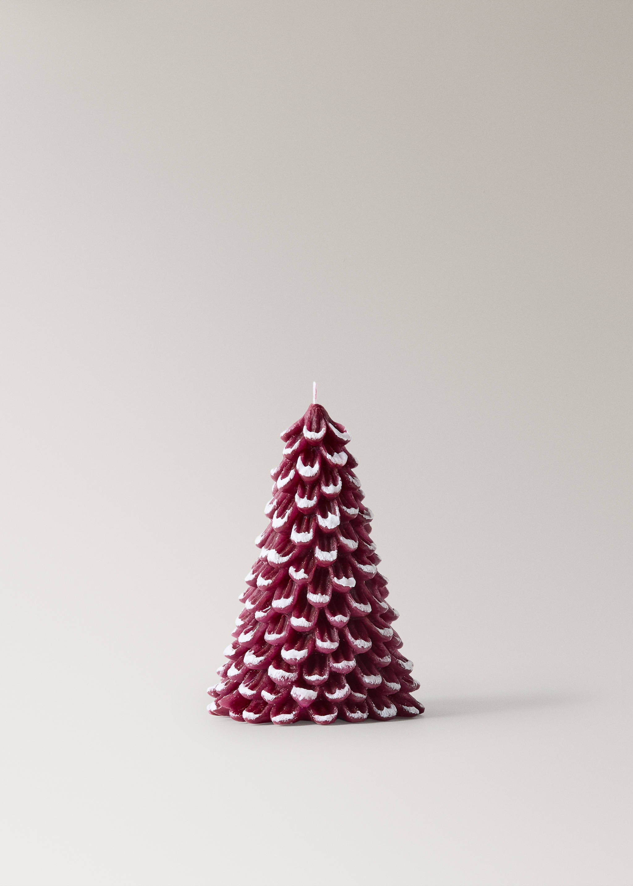 Burgundy pine tree-shaped candle with textured snow-tipped scales.