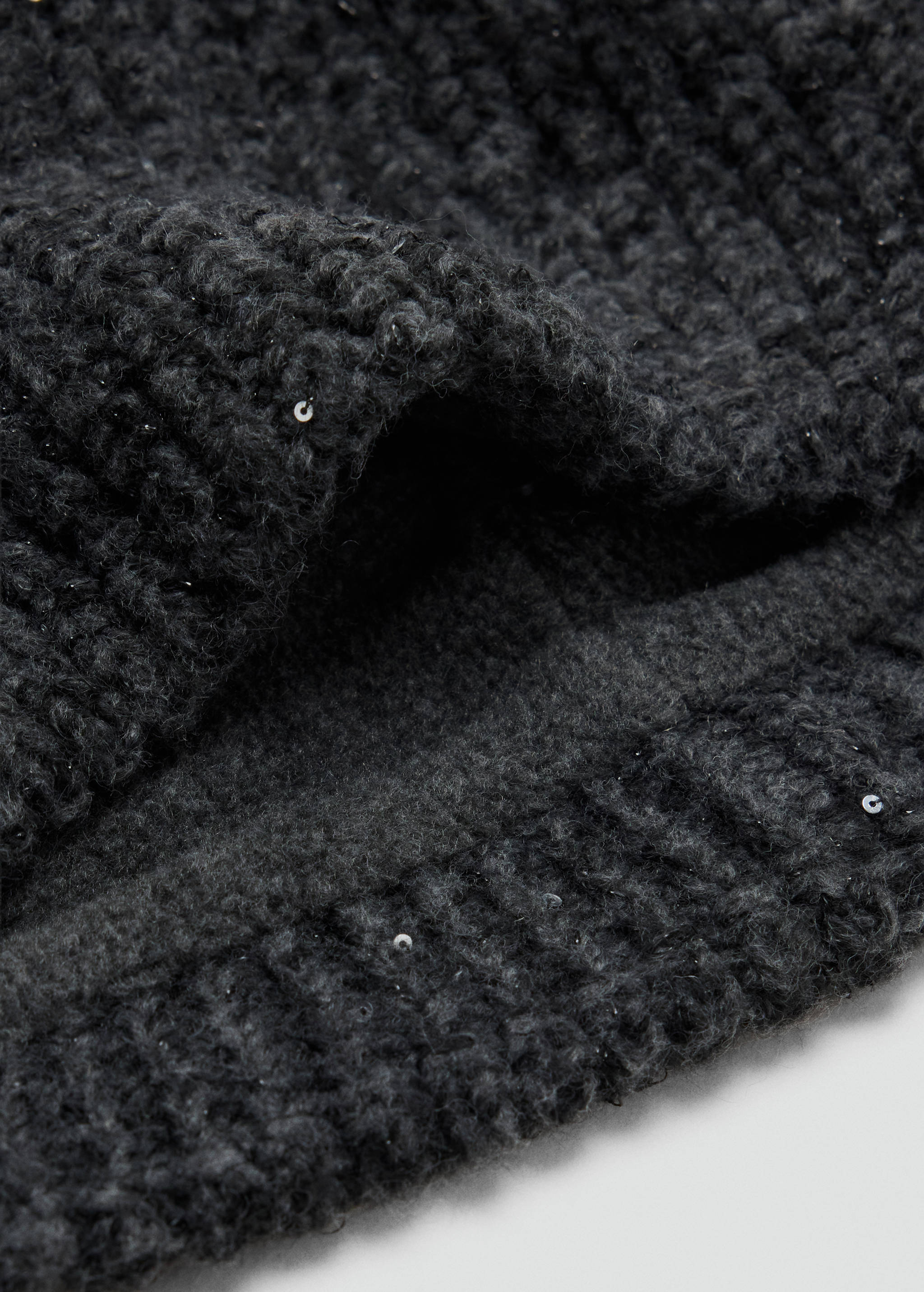 Dark grey knitted scarf with sequin details in a close-up view.