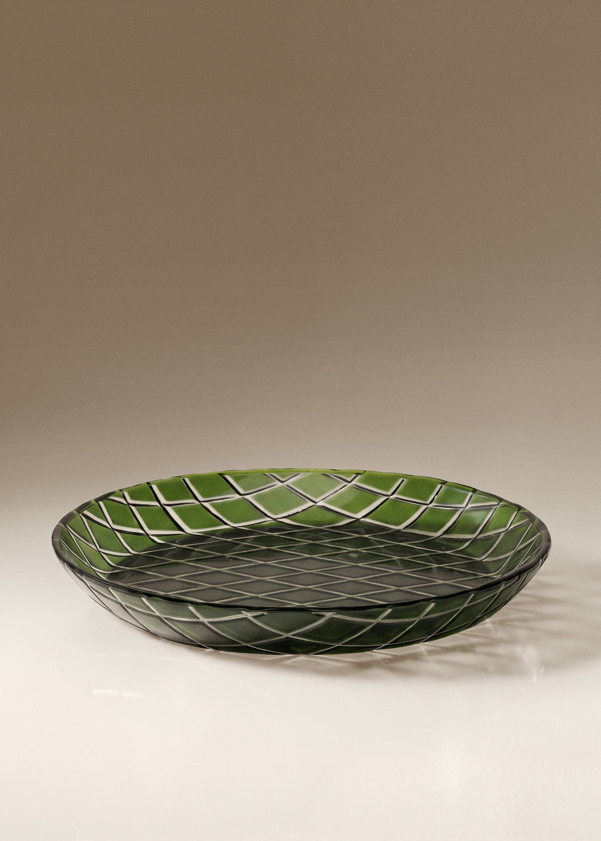 Green glass plate with a raised diamond lattice pattern.