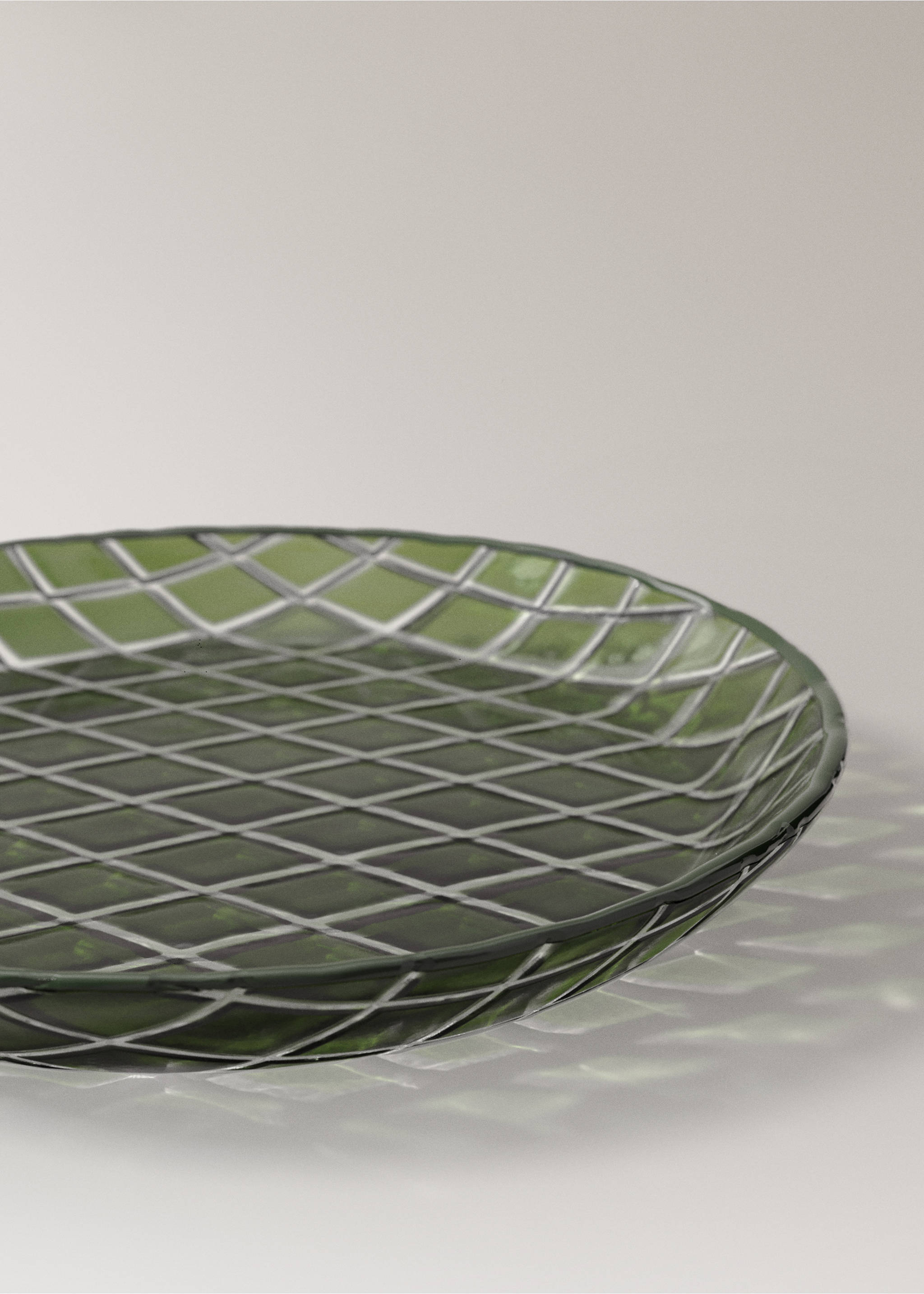 Green glass plate with a raised checkered pattern in close-up., Green. Ref: 37067901-00.