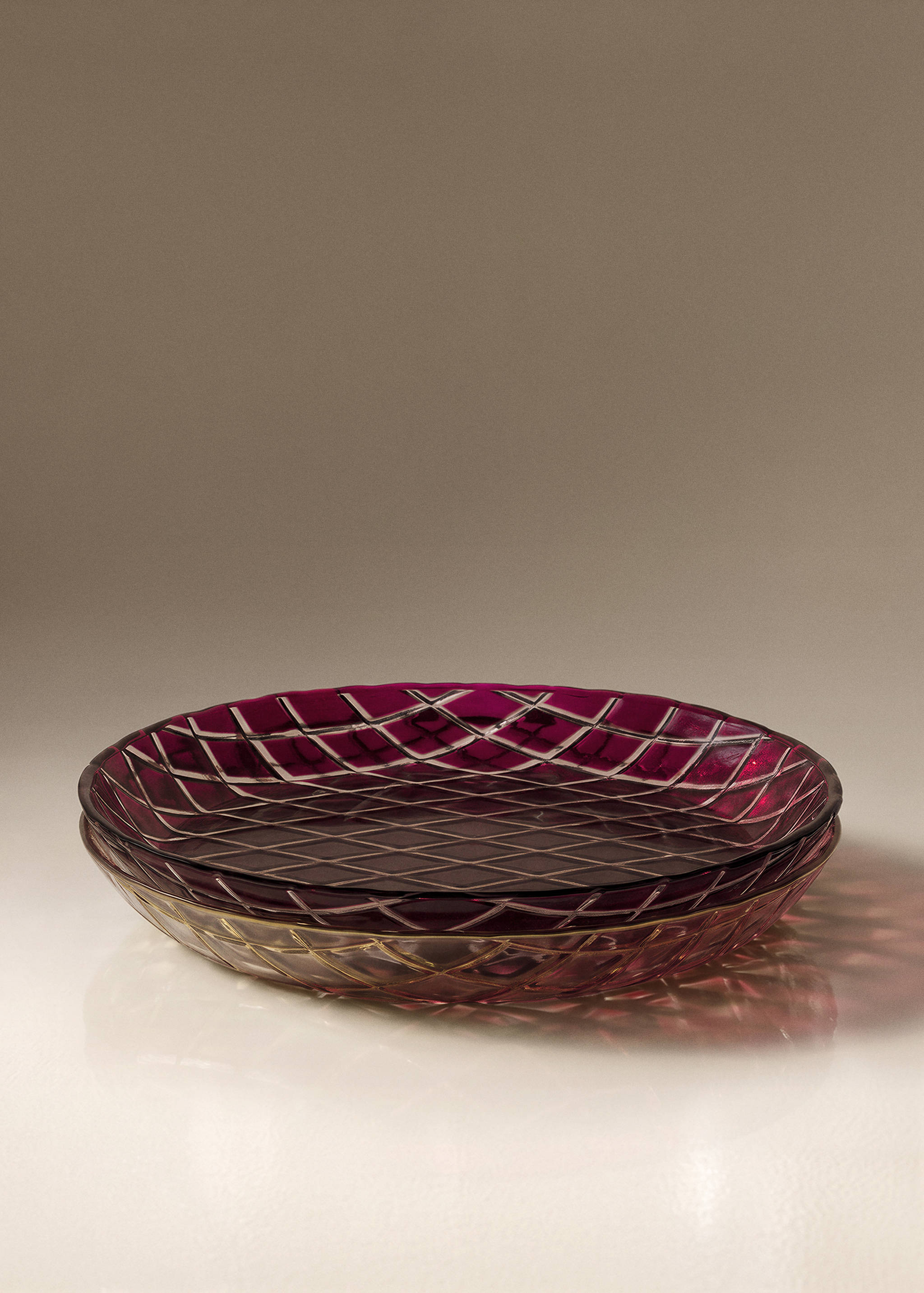 Dark magenta glass plates with a cut-glass lattice pattern.