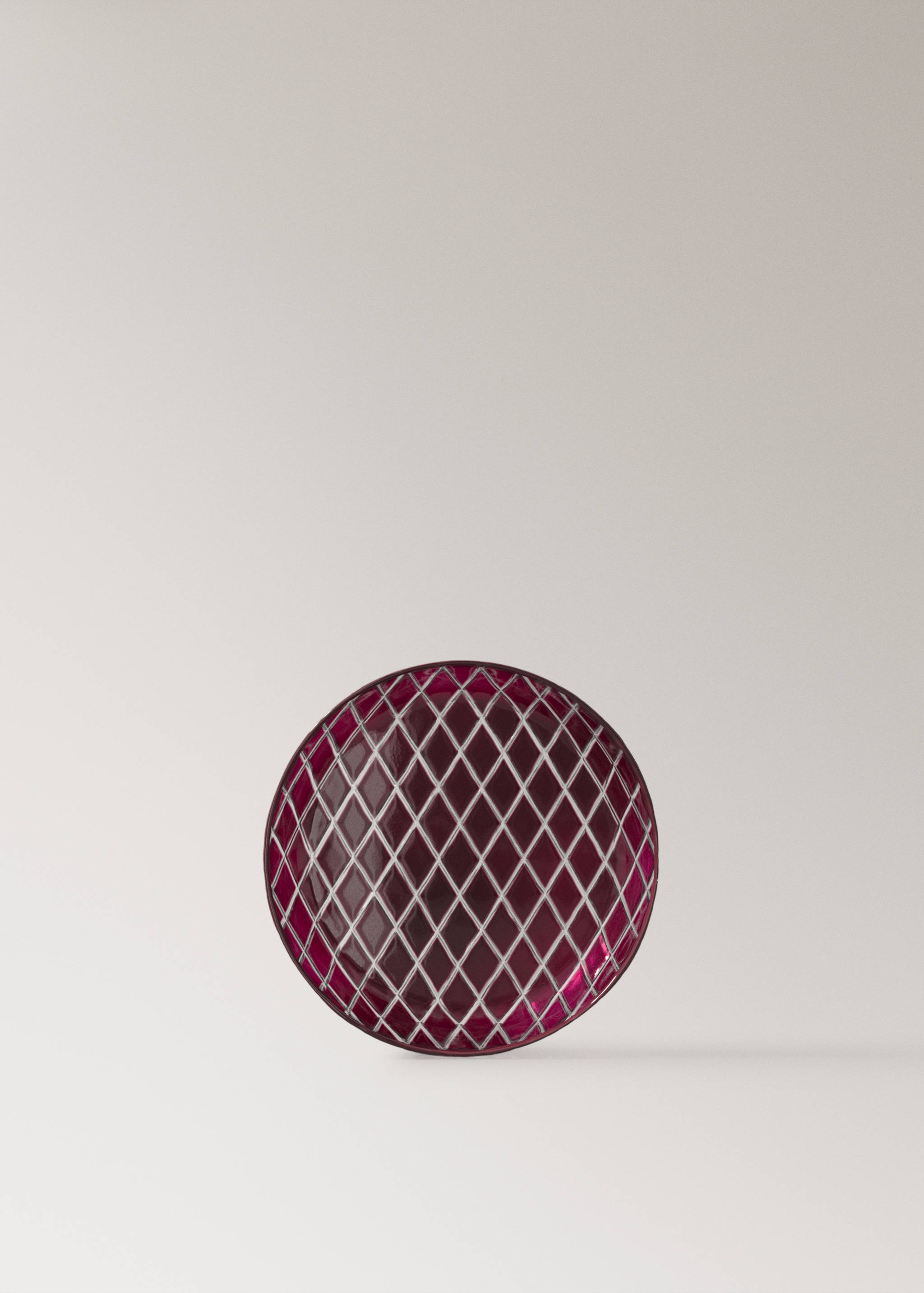Round deep pink glass plate featuring a raised white diamond lattice pattern.