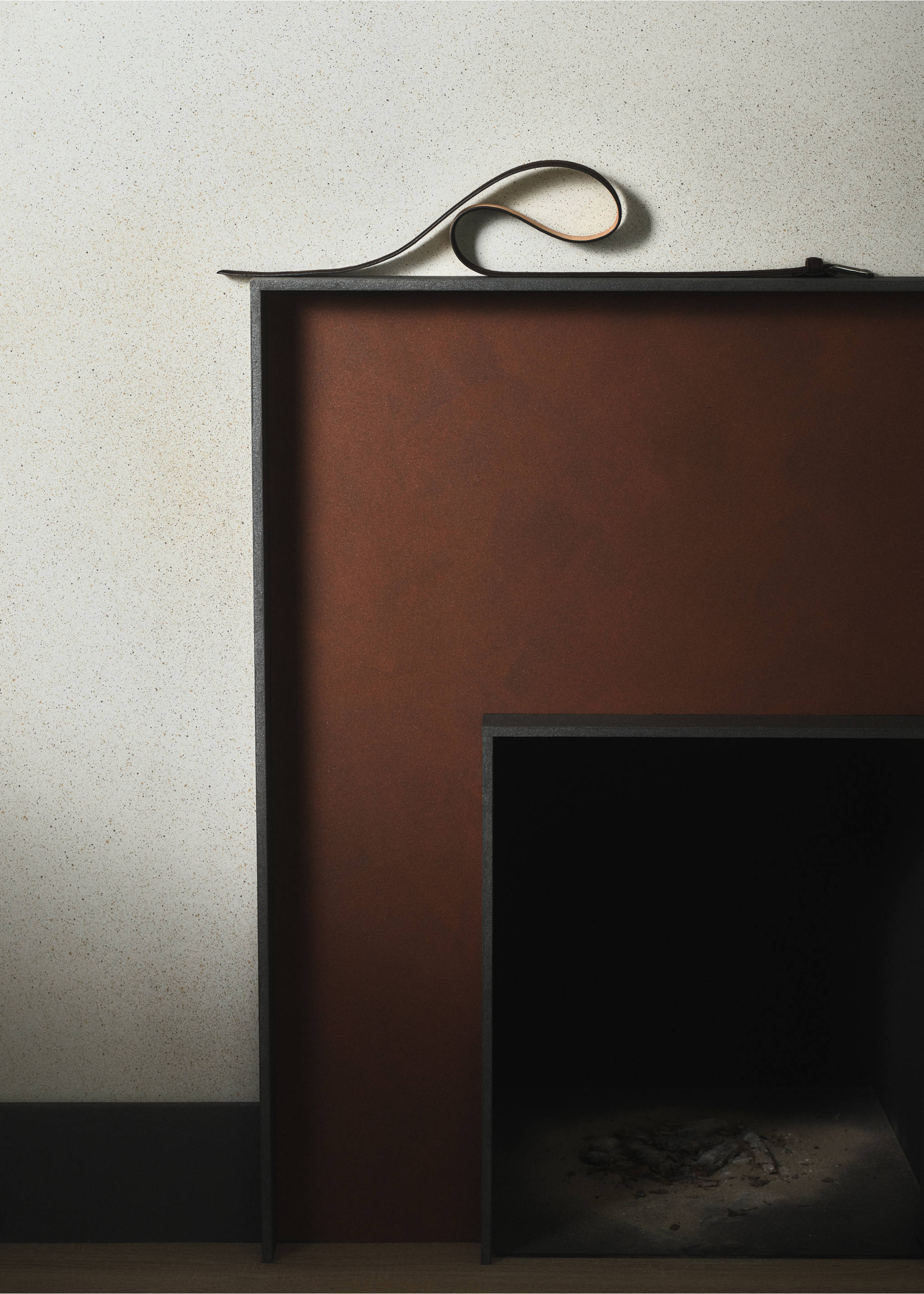 Dark brown leather belt coiled on a fireplace mantel., Chocolate. Ref: 37067903-00.