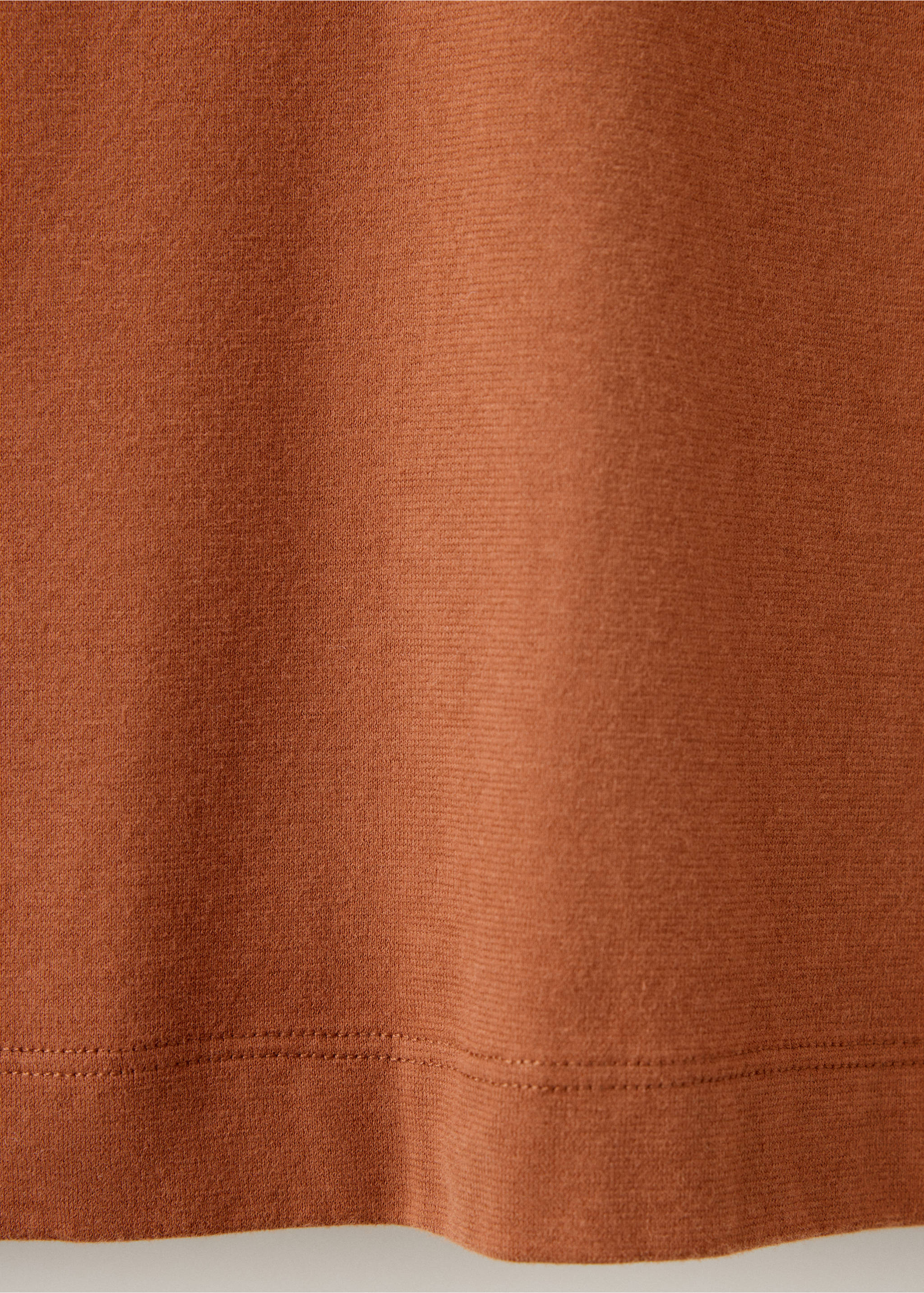 Close-up of the rust-brown t-shirt fabric texture and hem detail., Burnt Orange. Ref: 37067912-00.