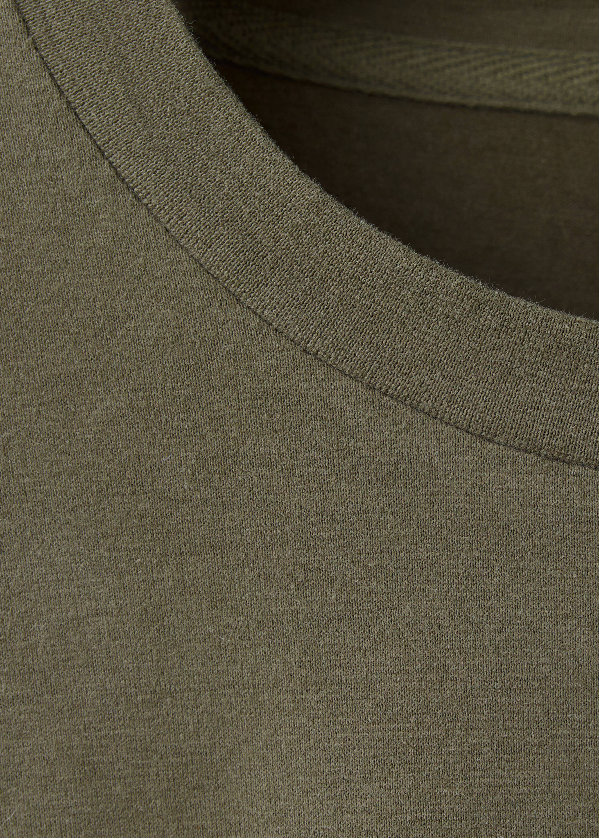 Close-up of an olive green t-shirt showing the ribbed crew neckline.