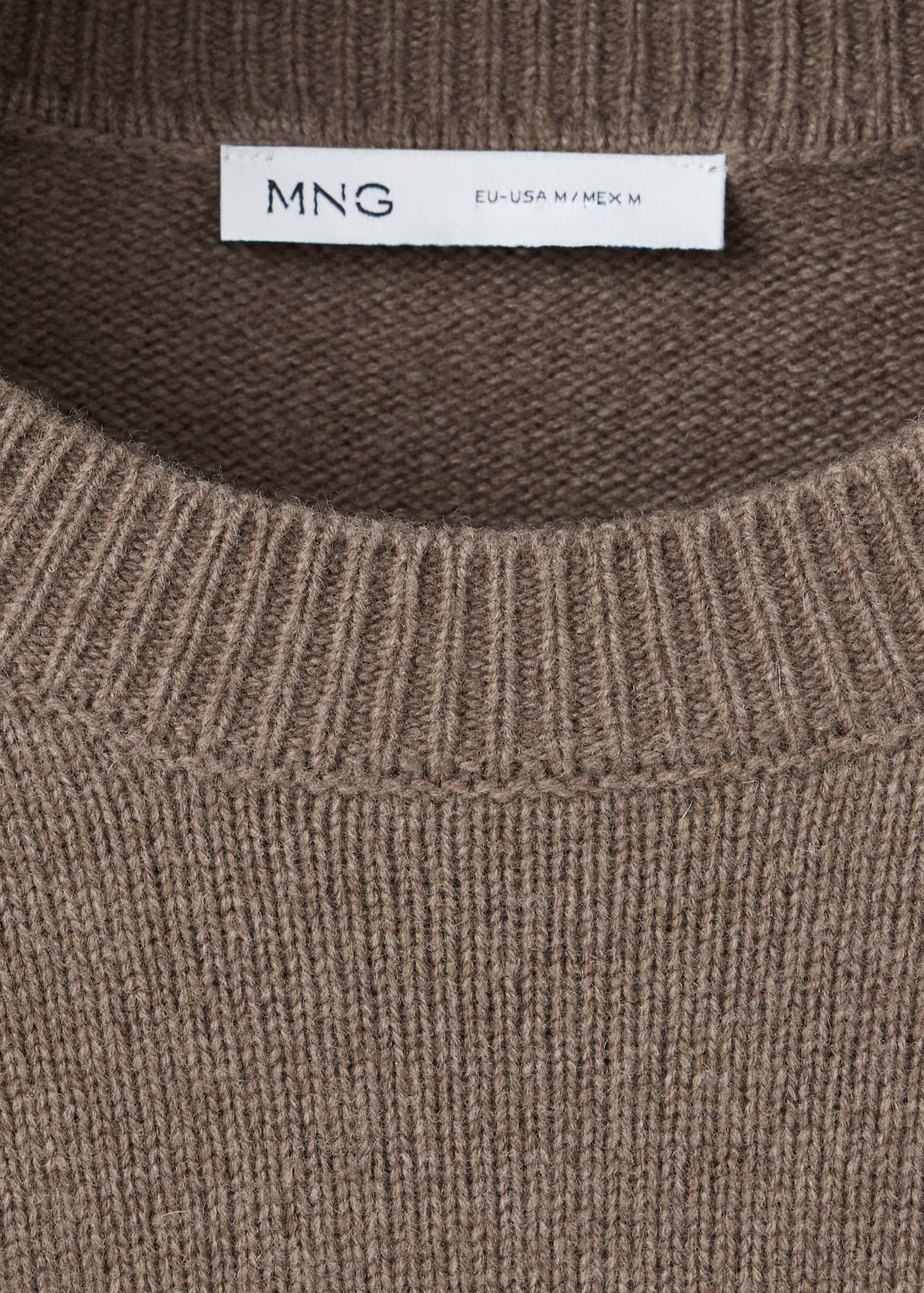 Close-up of a brown knitted jersey focusing on the ribbed round neckline and brand label.
