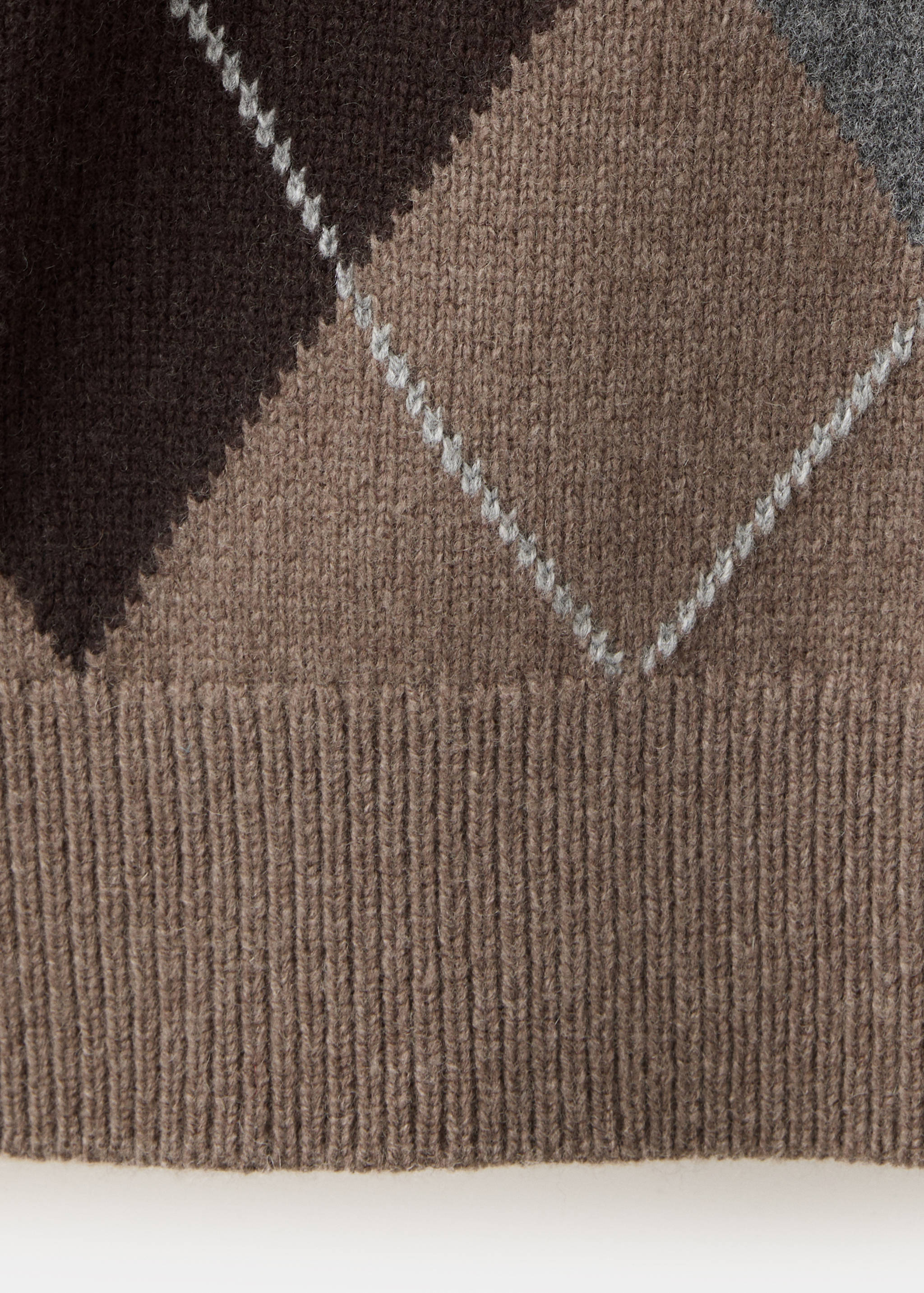 Close-up of an argyle knit jersey showing the pattern and ribbed hem.