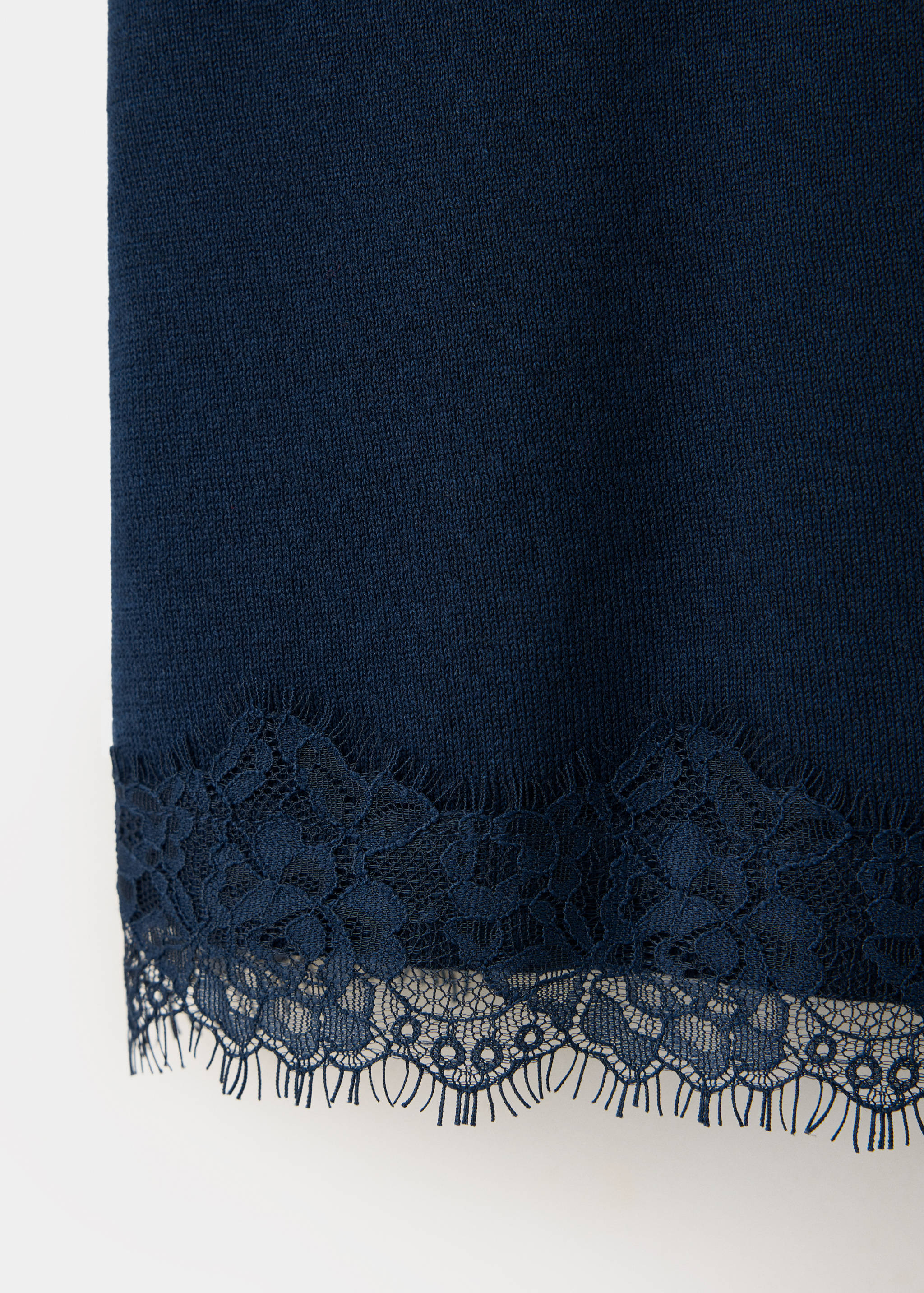 Close-up of the dark navy knit top, showing the fine texture and lace trim.