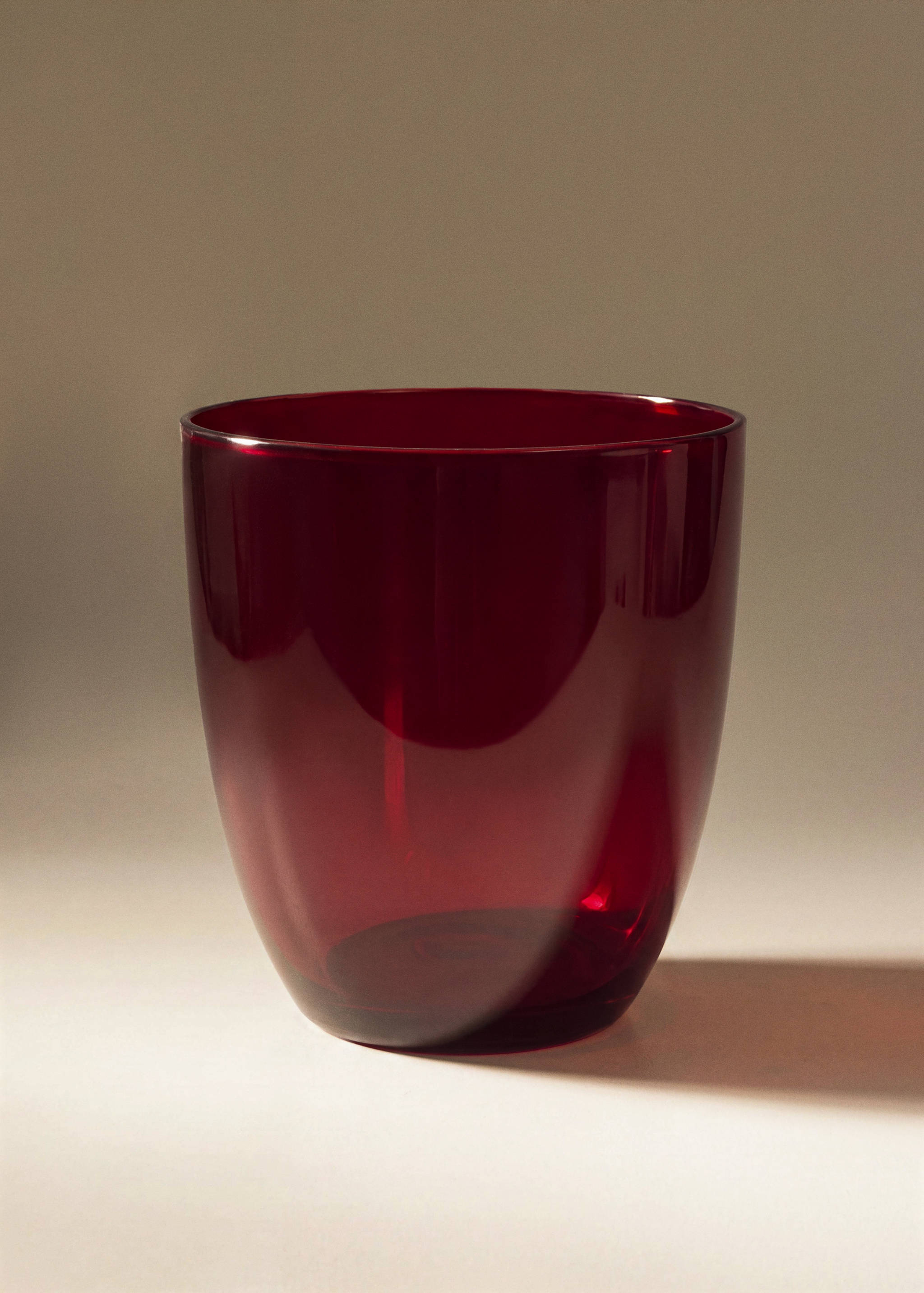 Red glass tumbler with a smooth cylindrical design.