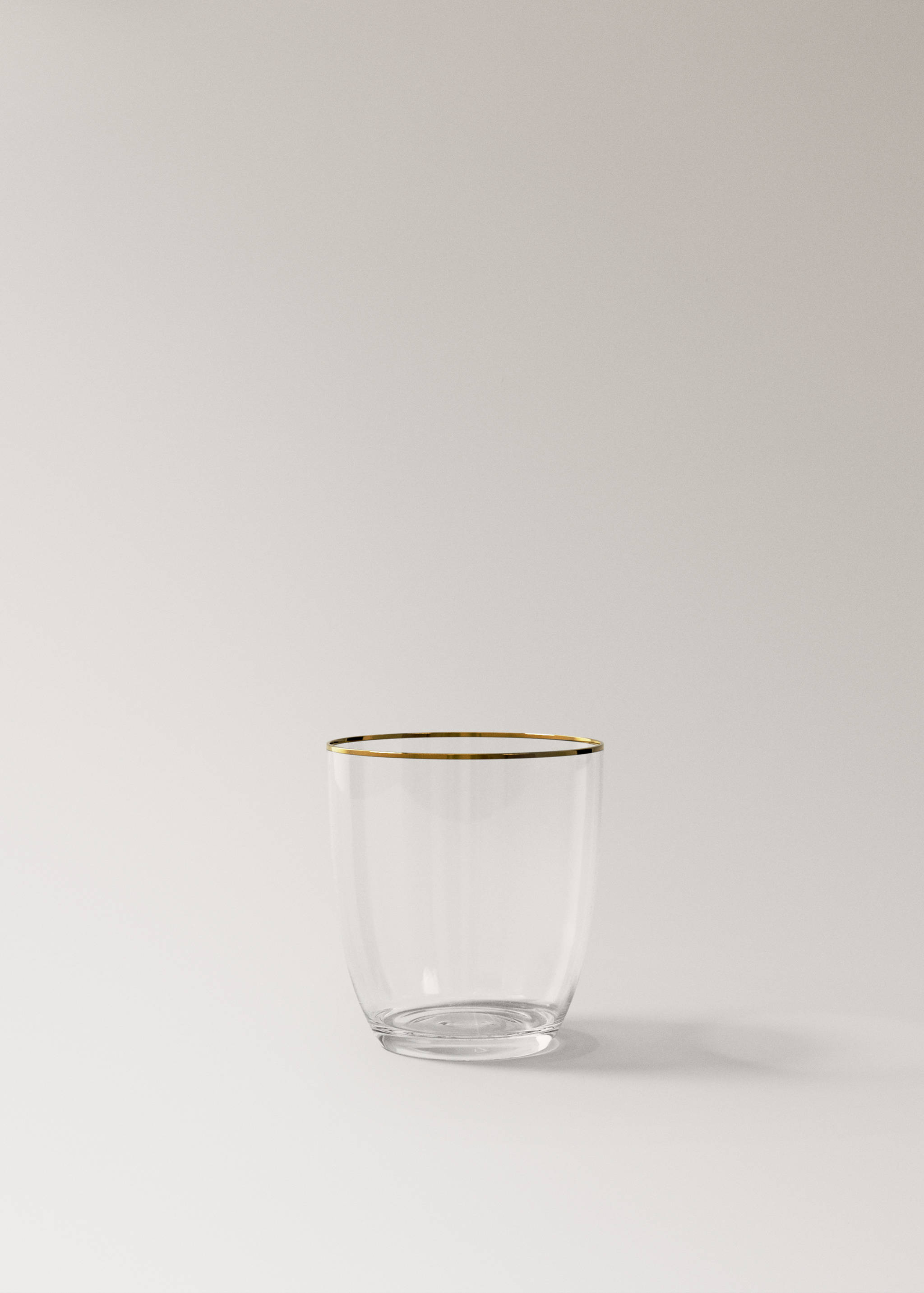 Clear glass tumbler with a thin gold-coloured rim.