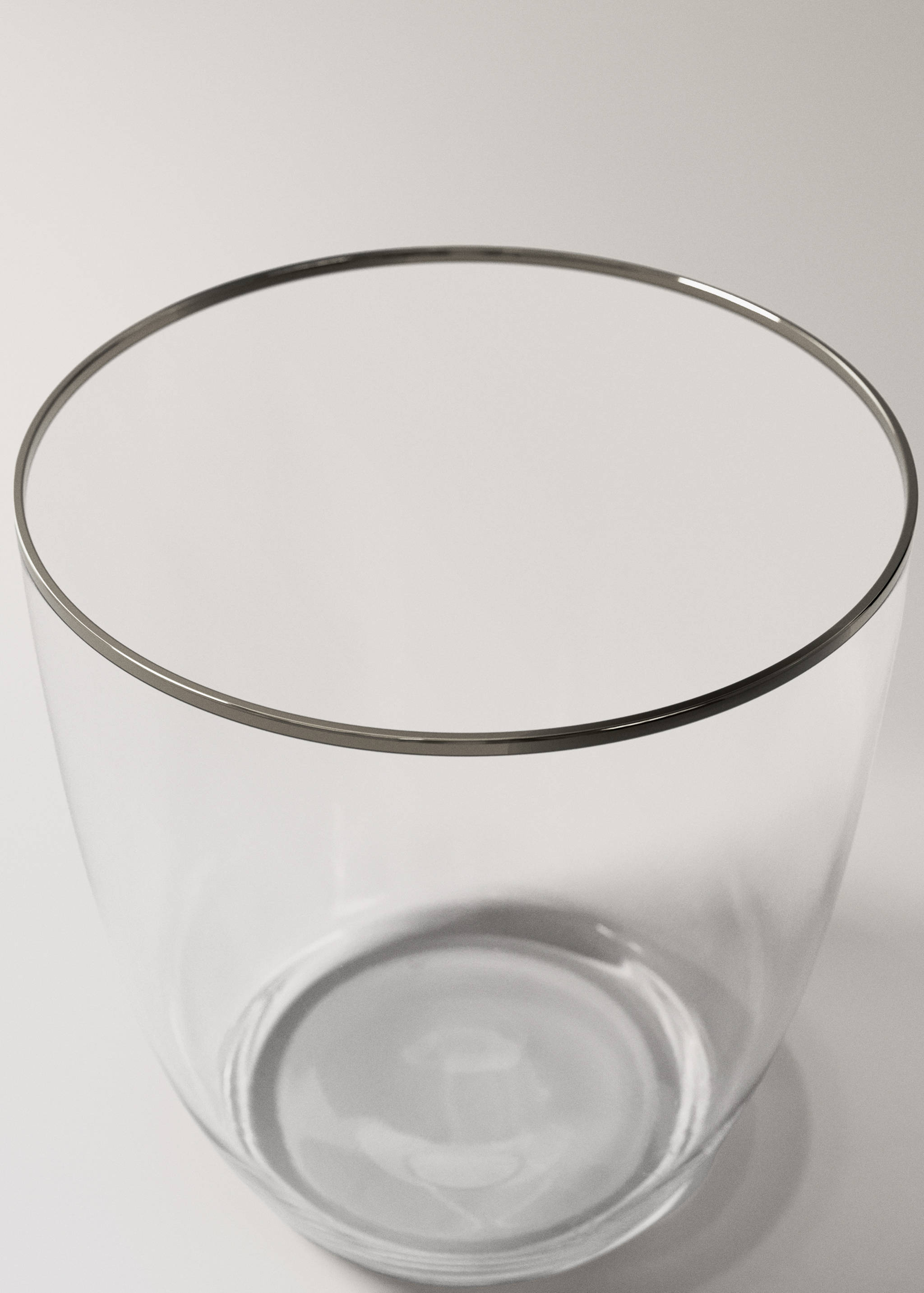 Close-up of a clear glass tumbler with a metallic silver-rimmed edge.
