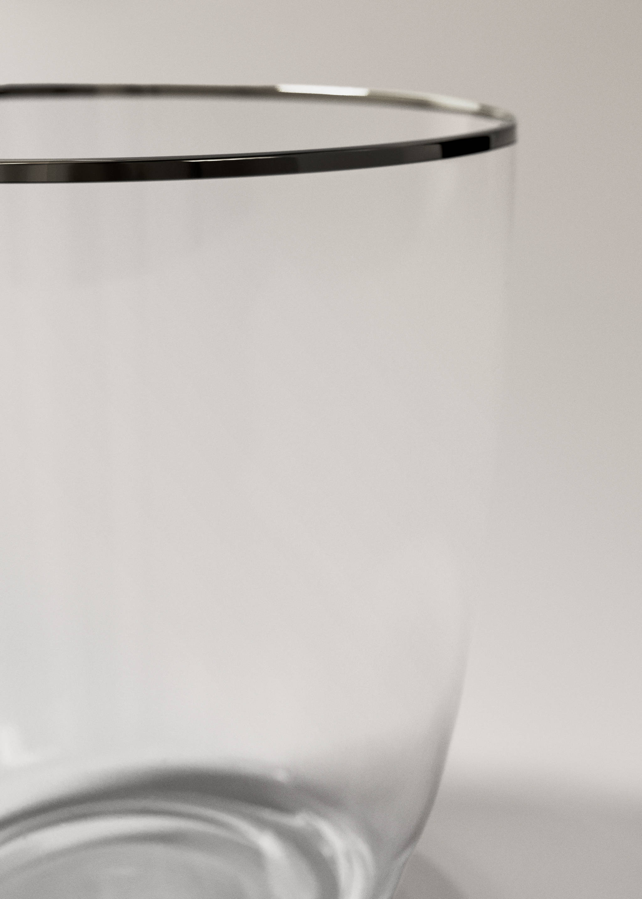 Close-up of a clear glass tumbler with a silver rim.