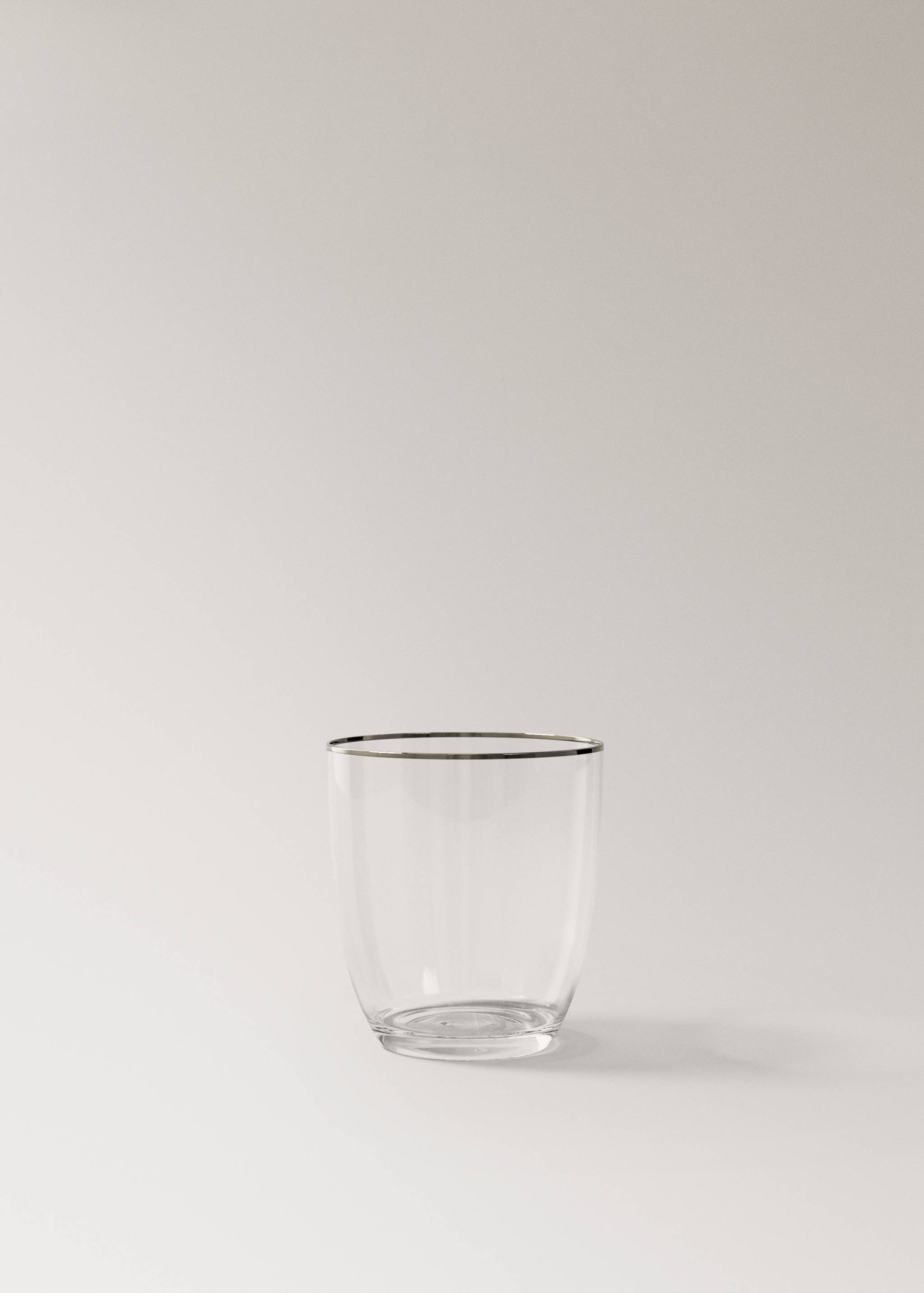 Clear glass tumbler with a metallic silver-coloured rim.