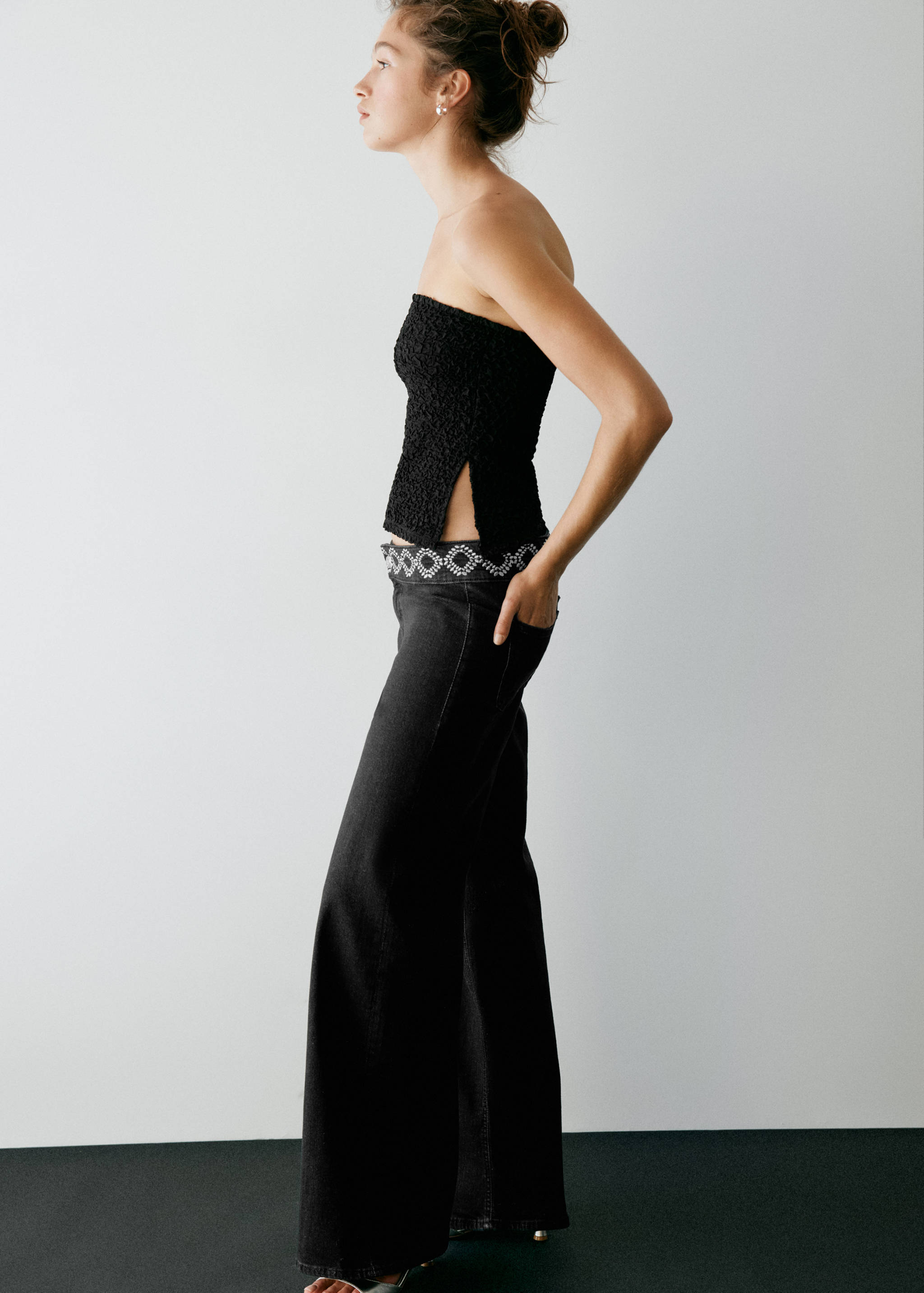 Black denim trousers with a jewelled waistband.