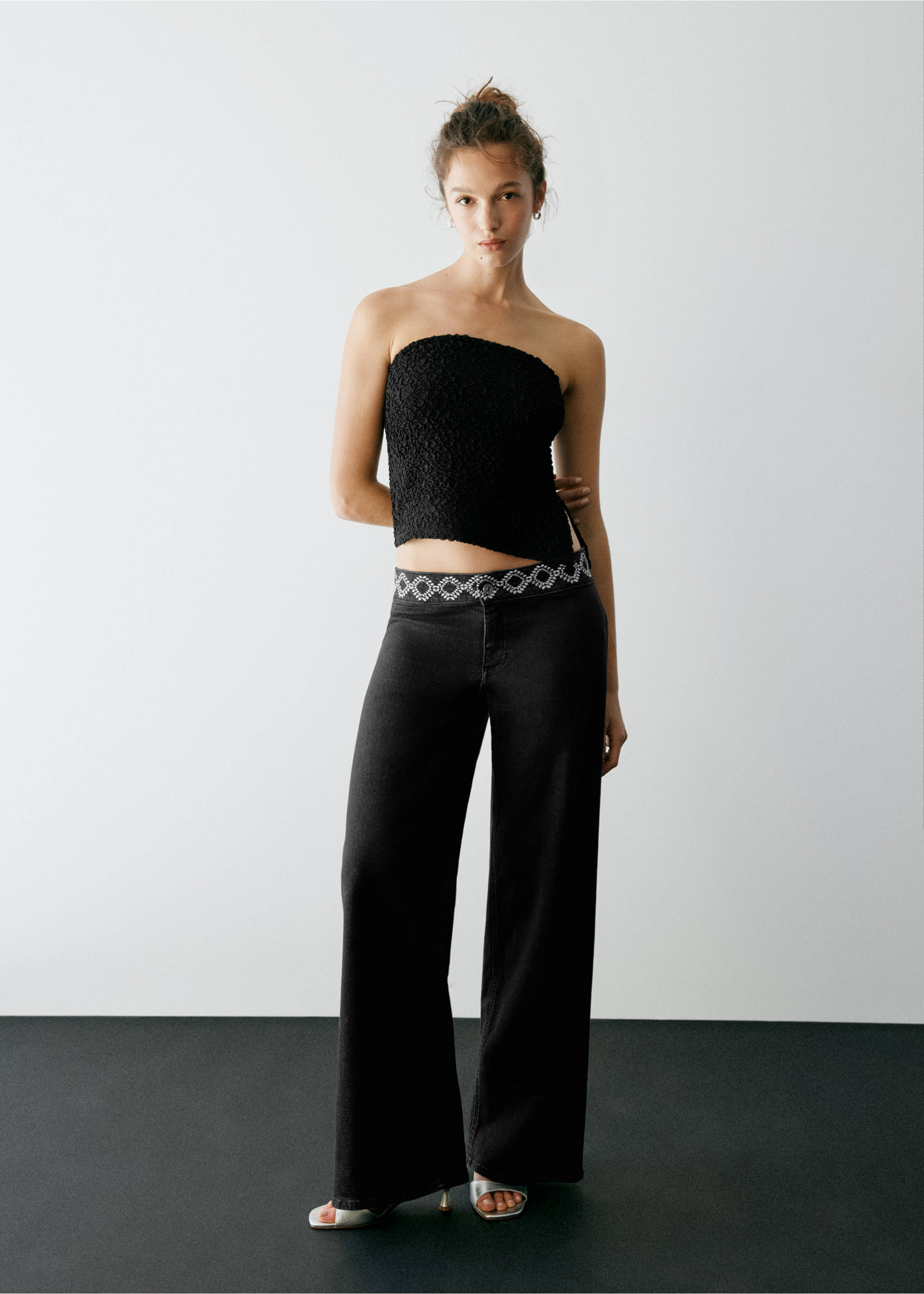 Black strapless textured top with an asymmetrical hem, worn with black trousers., Black. Ref: 37067929-00.