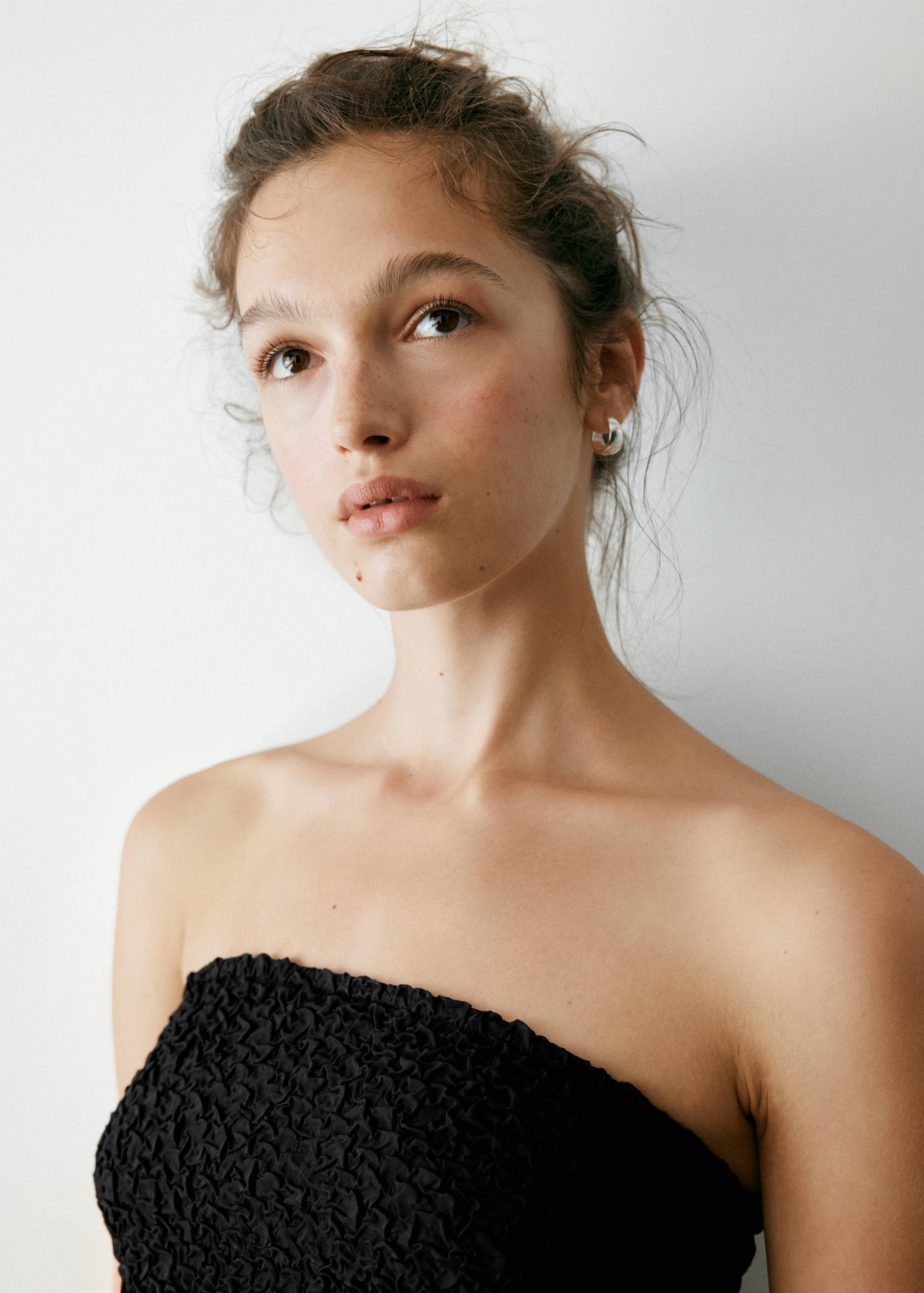 Black strapless bandeau top with a textured crinkle finish.