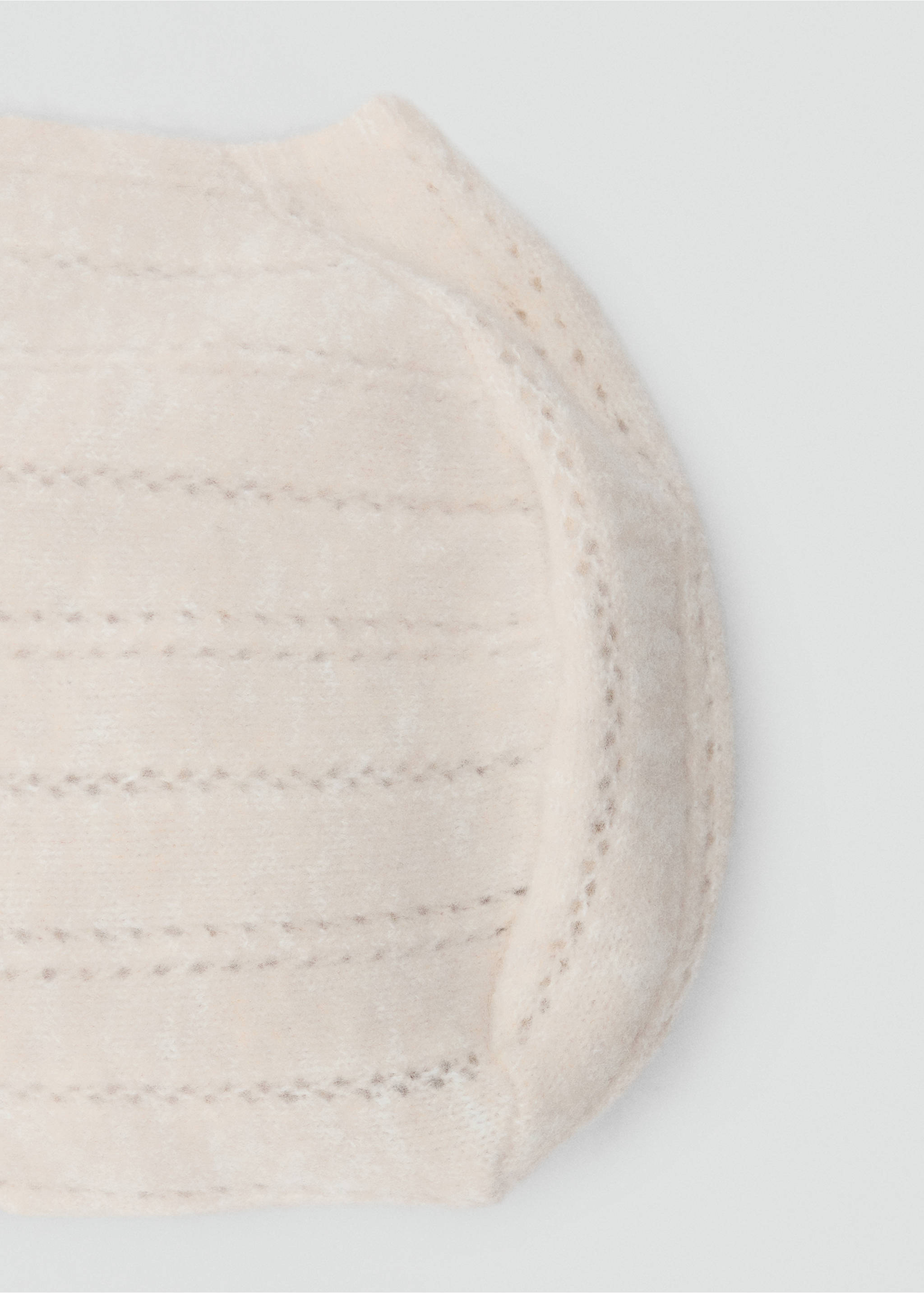 Close-up detail of a beige knit hat with ribbed texture and eyelet trim., Beige. Ref: 37067931-00.