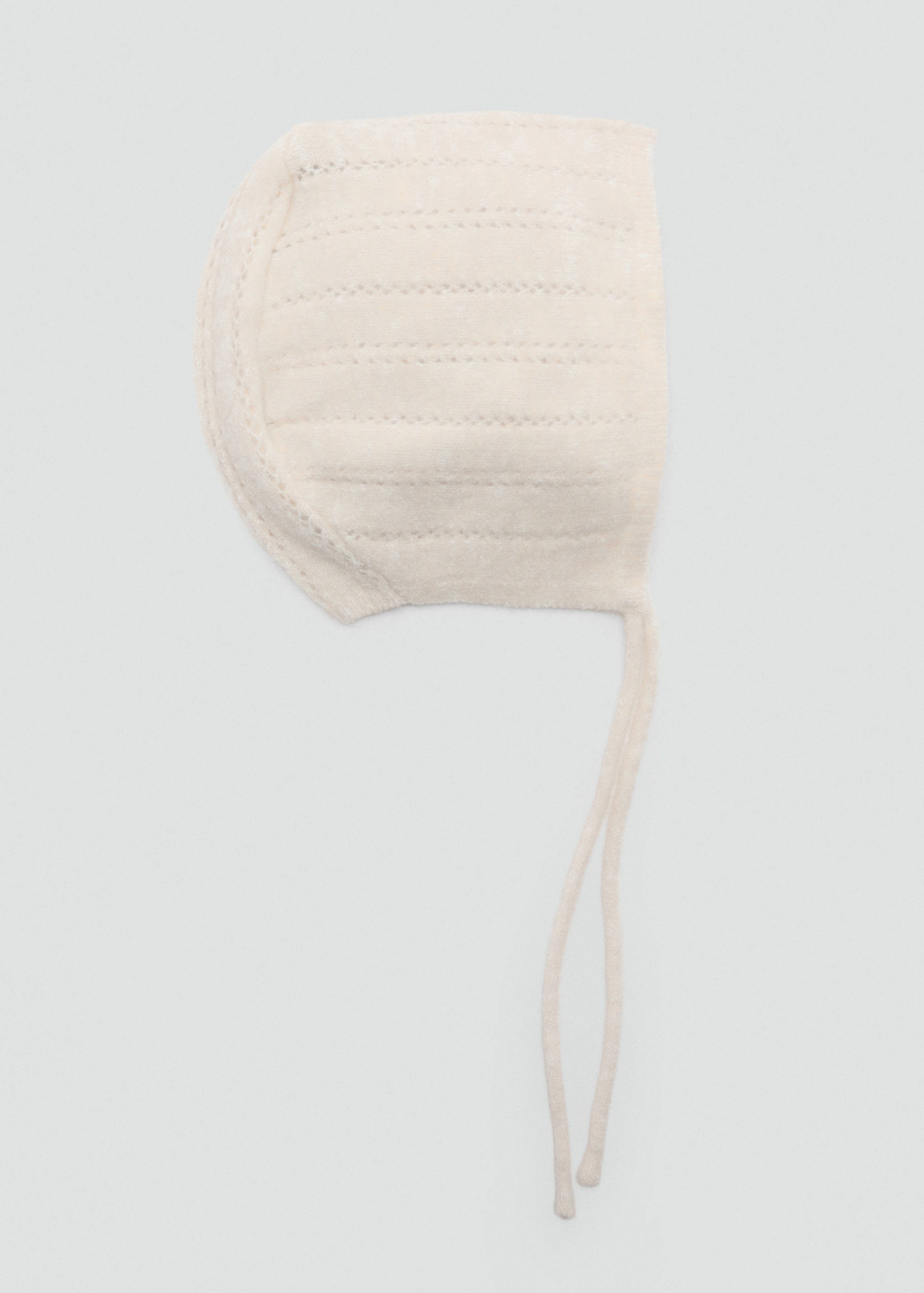 Off-white knitted baby bonnet with ribbed texture and chin ties.