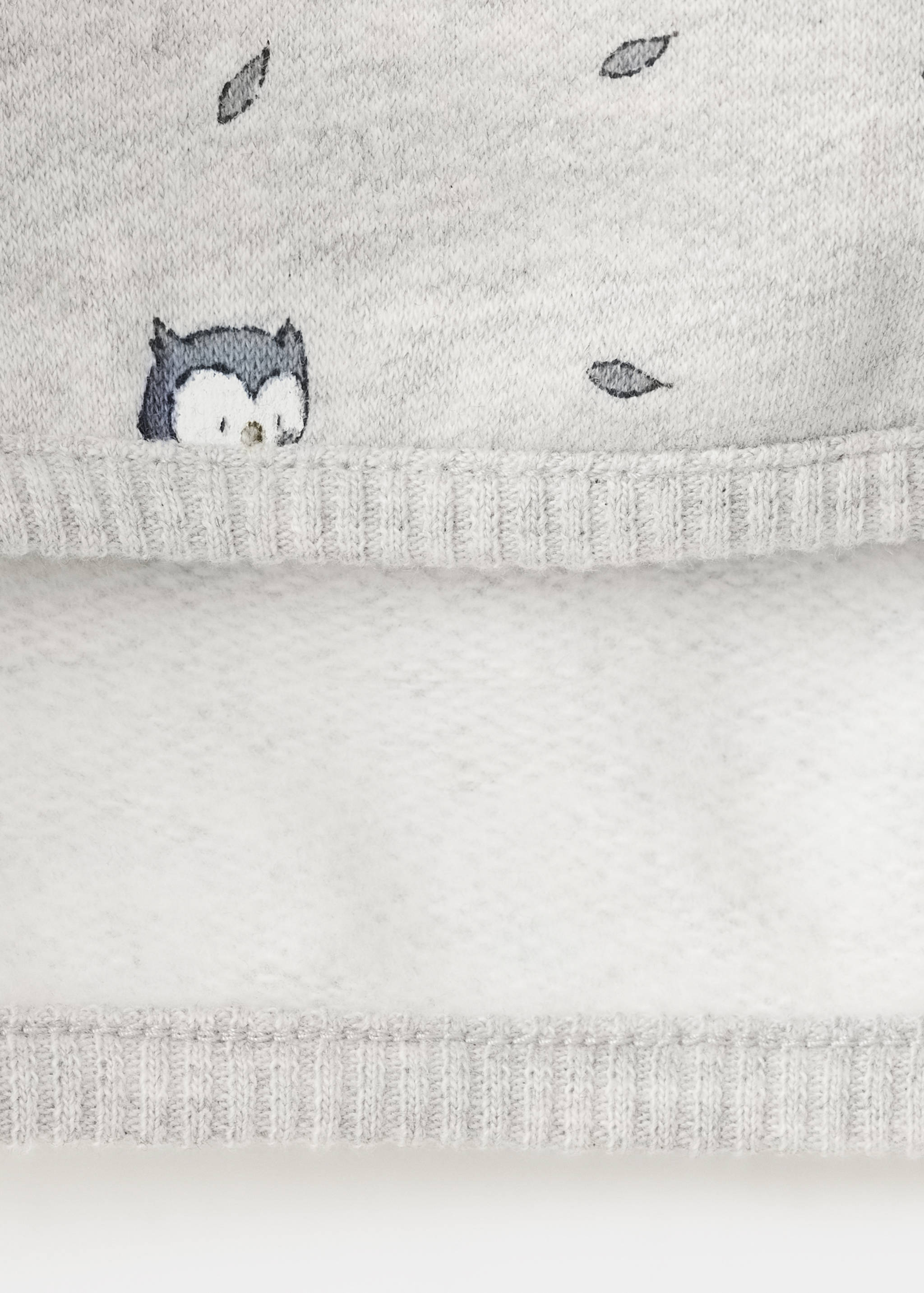 Close-up of grey sweatshirt fabric with fleece interior and owl print.