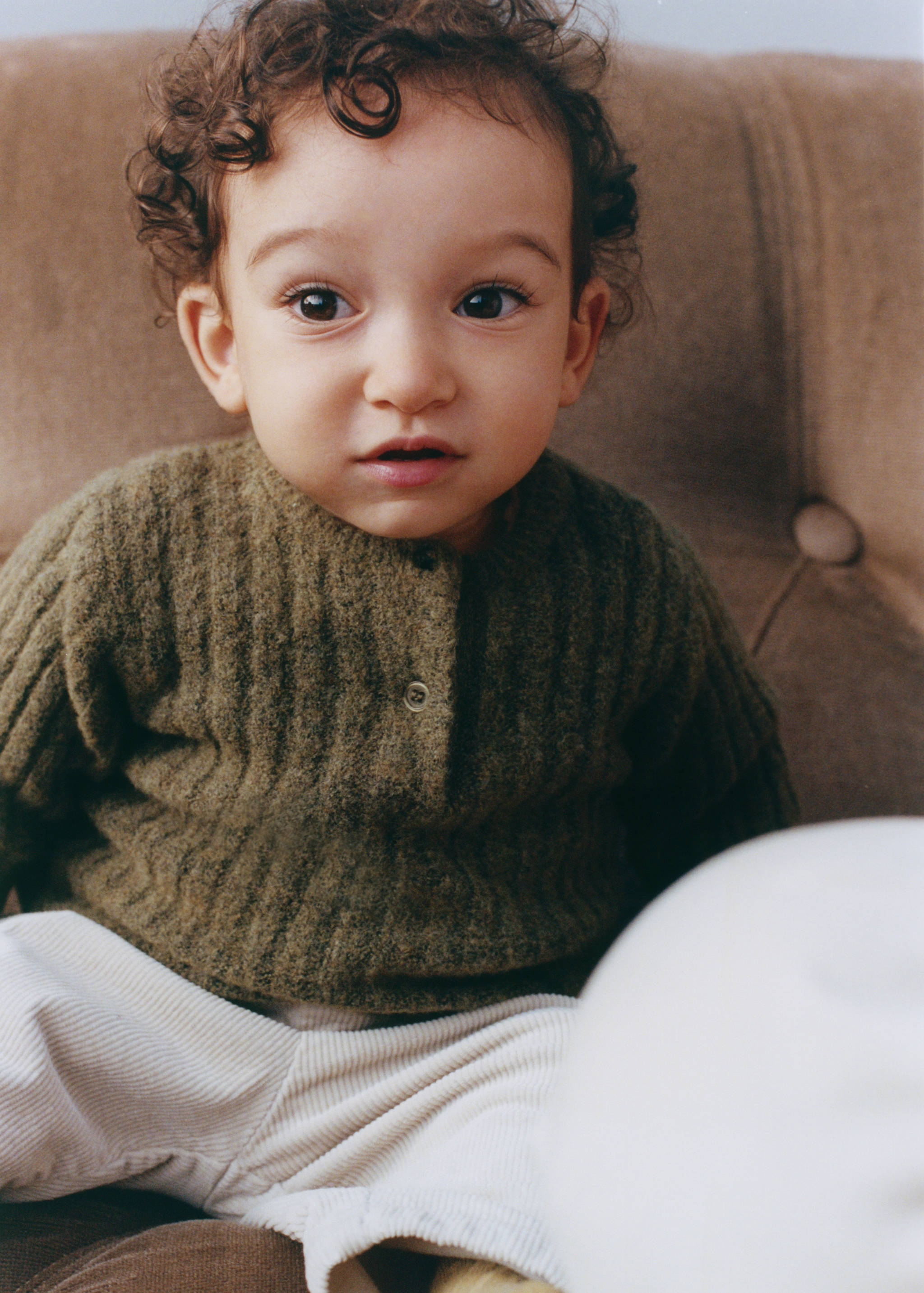Dark green ribbed knit jersey with buttons, worn by a child.